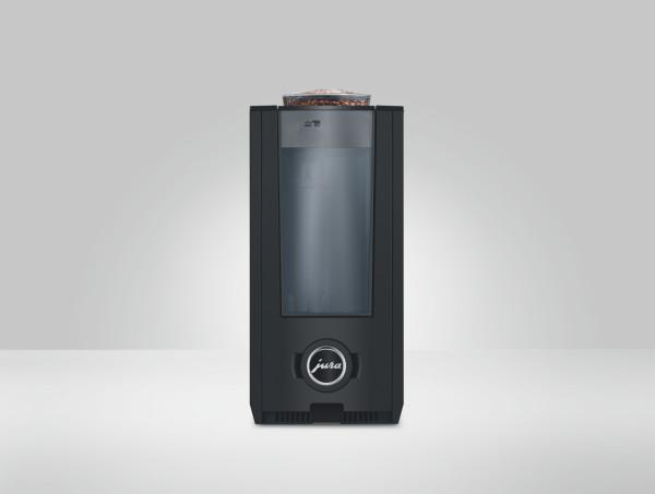 Eine schwarze Jura-Kaffeemaschine steht auf einer weißen Oberfläche vor hellem Hintergrund.