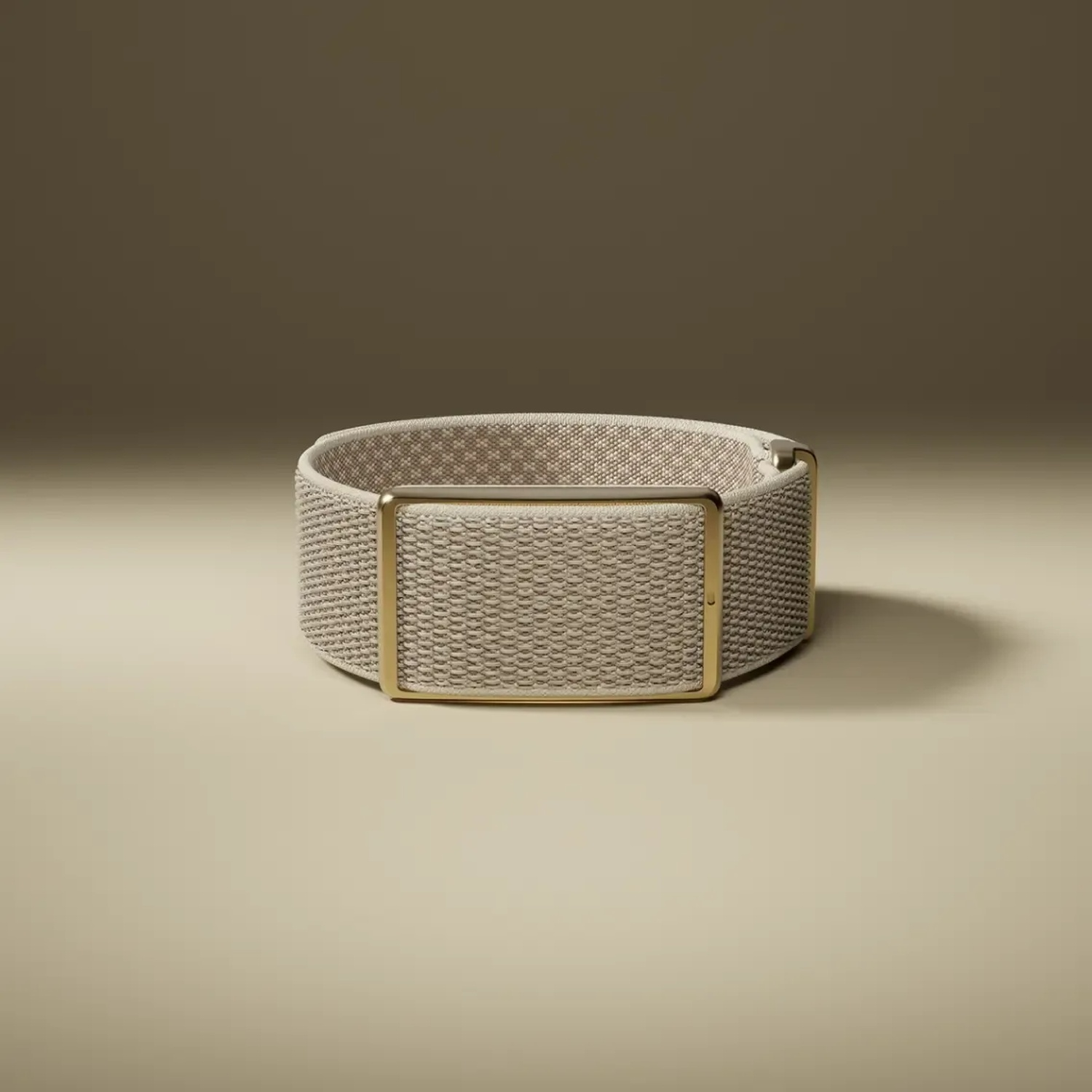 A beige braided watch strap with a gold metal buckle on a solid background.