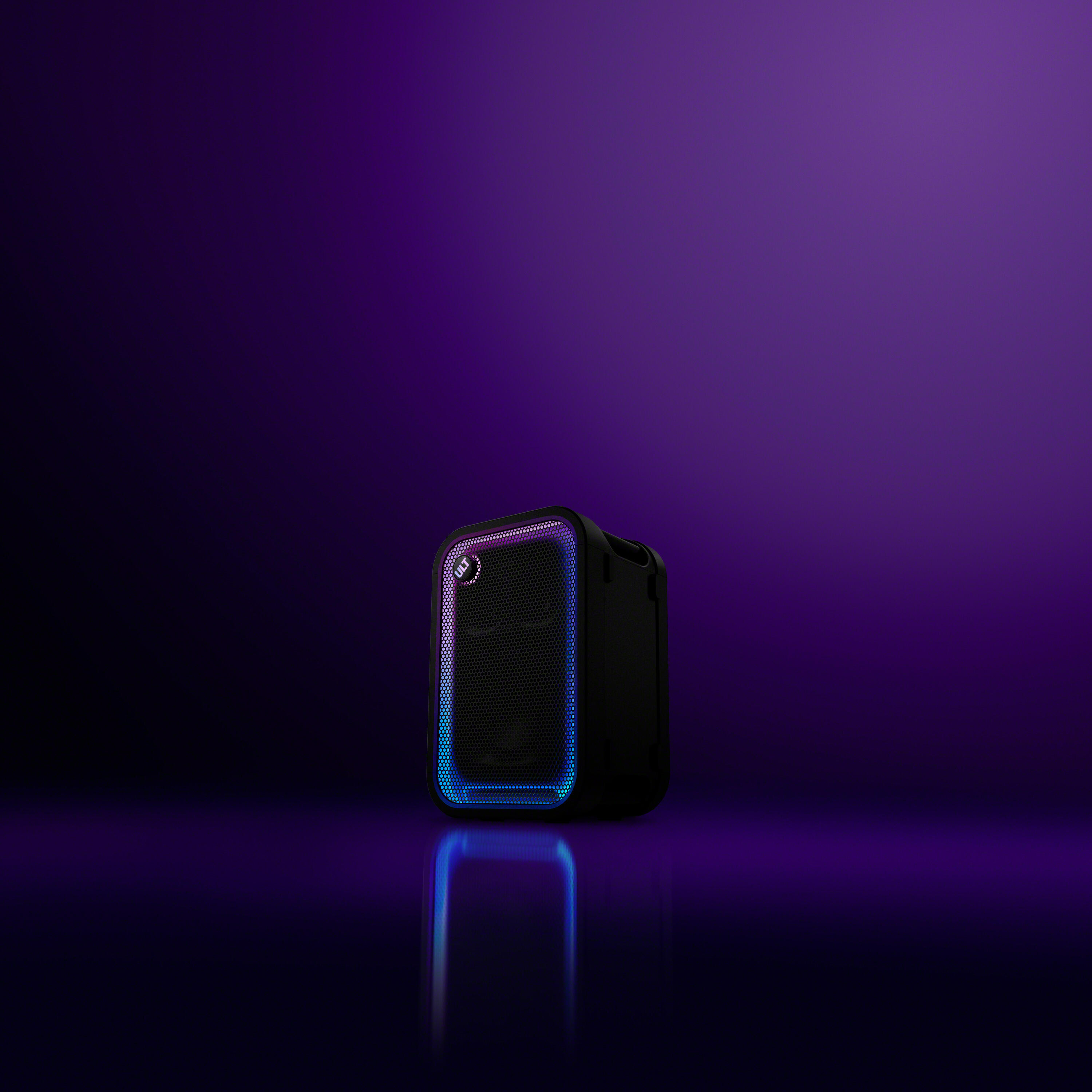 Un altavoz portátil negro con luces LED azules y moradas sobre una superficie brillante con fondo morado oscuro.