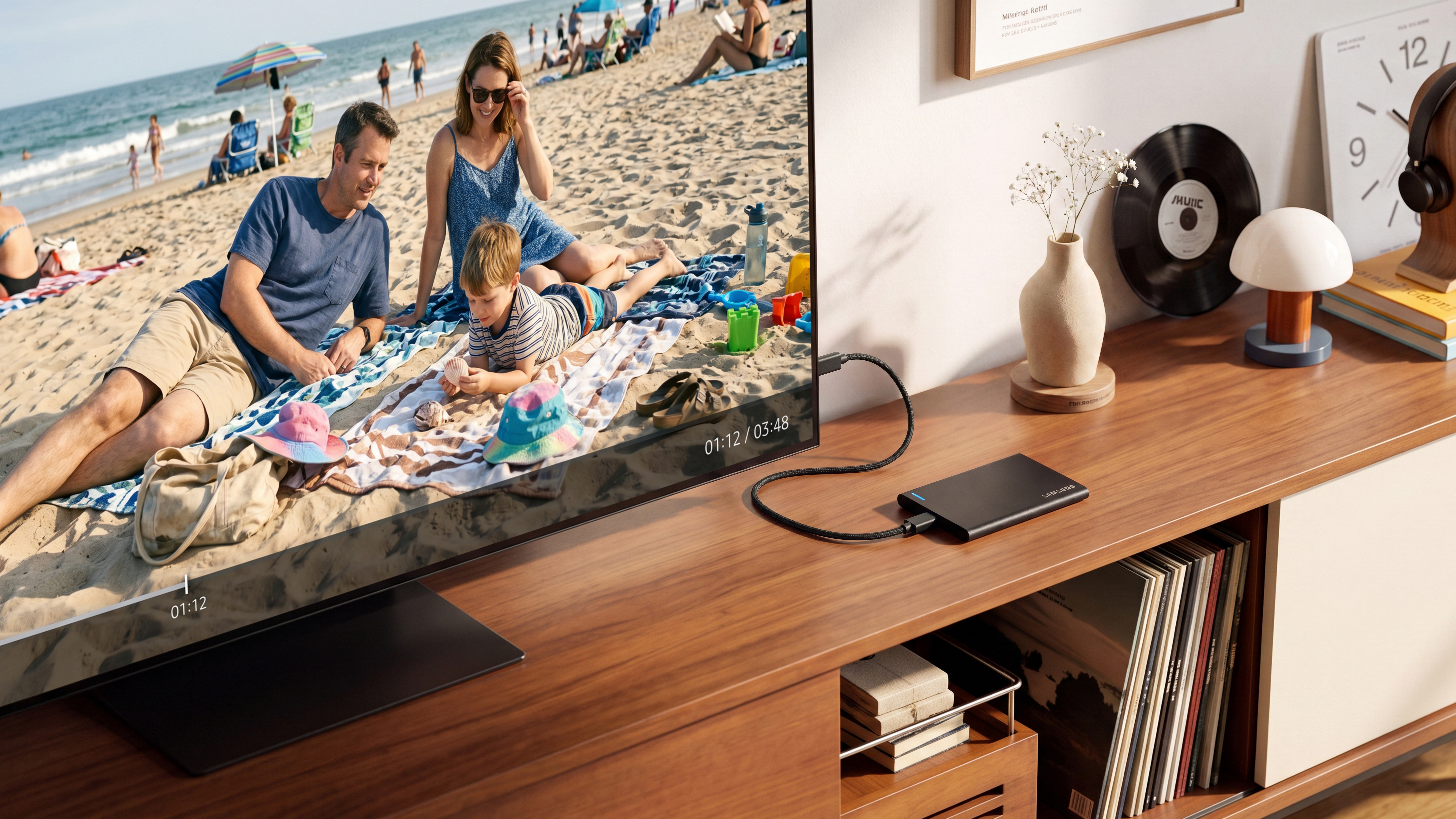 Ein Fernseher mit Strandbild steht auf einem Holzschrank neben einer externen Festplatte.