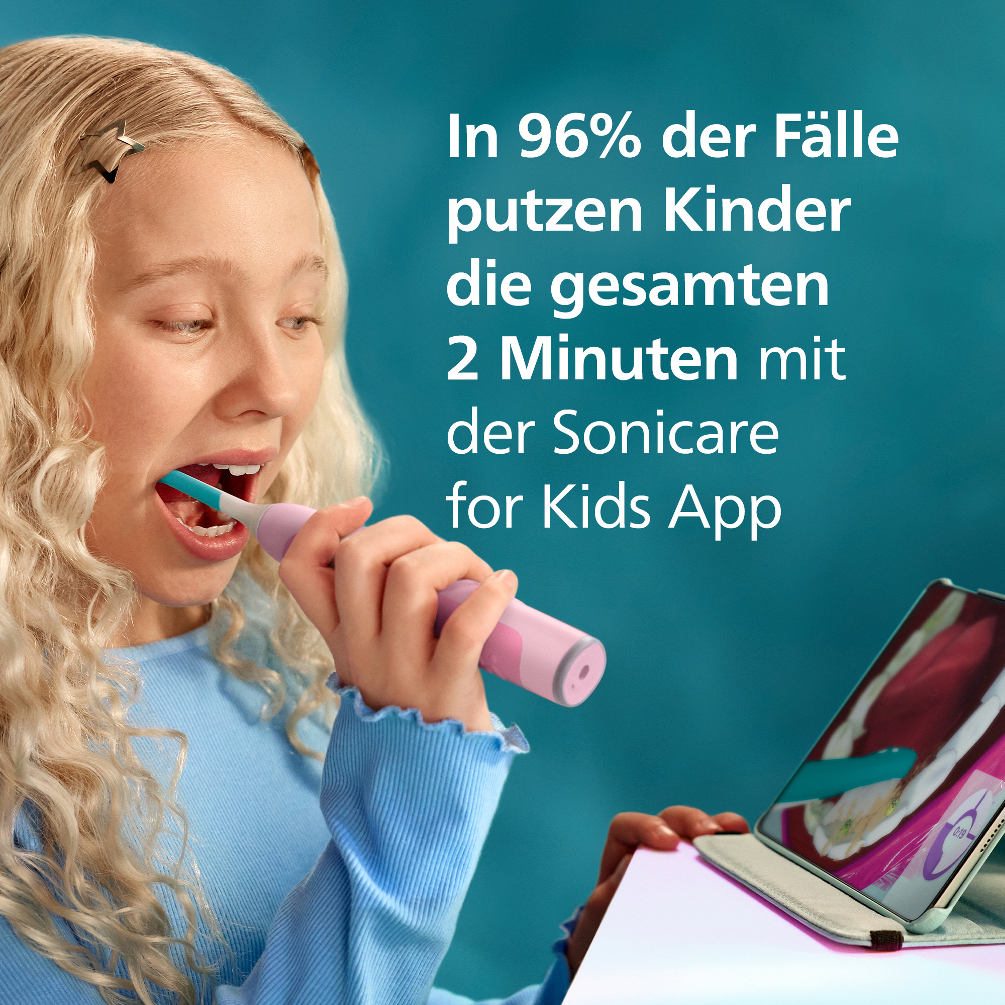 Una bambina bionda si lava i denti guardando un'app su un tablet.