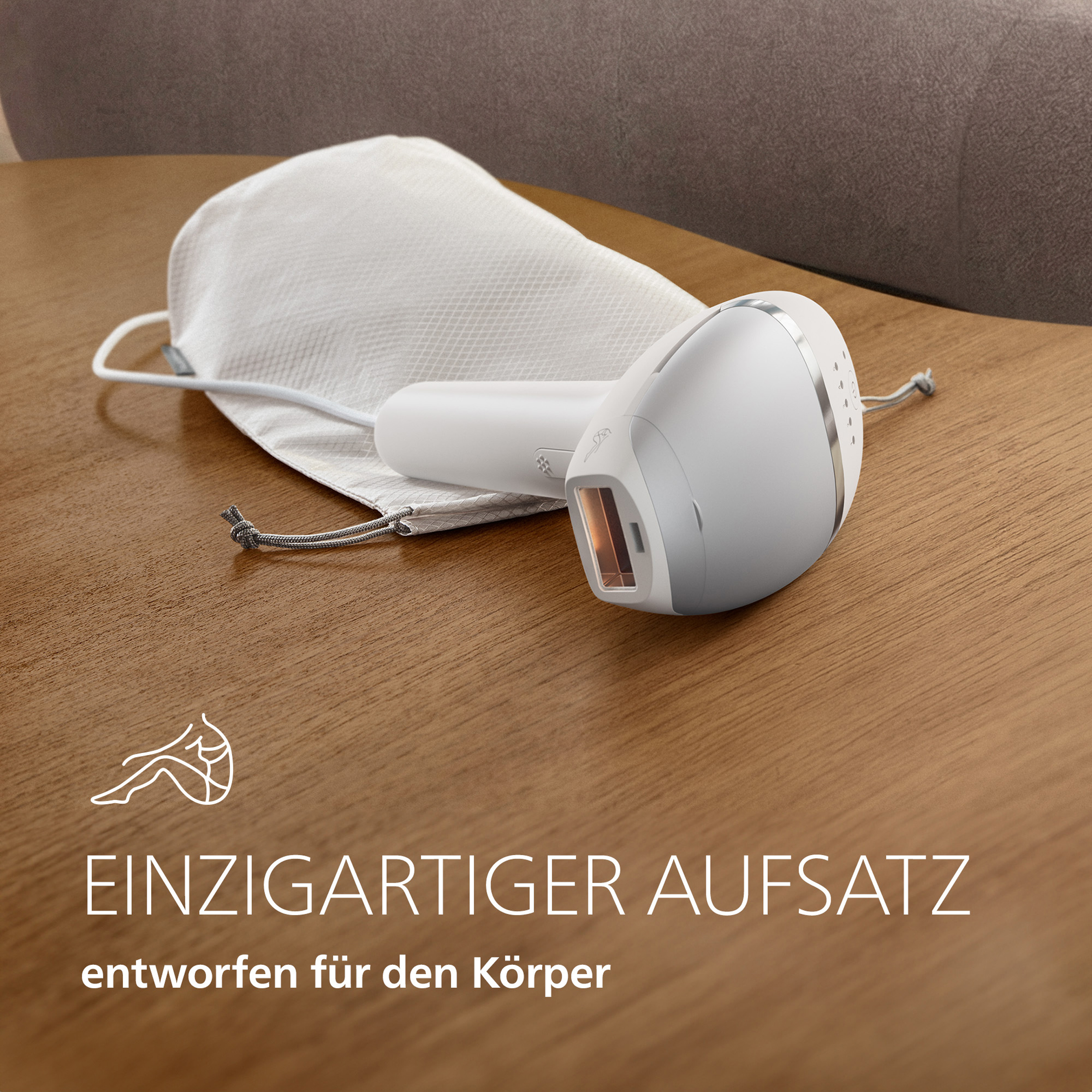 Ein weißes IPL-Haarentfernungsgerät und eine Stofftasche auf einem Holztisch mit deutschem Text.