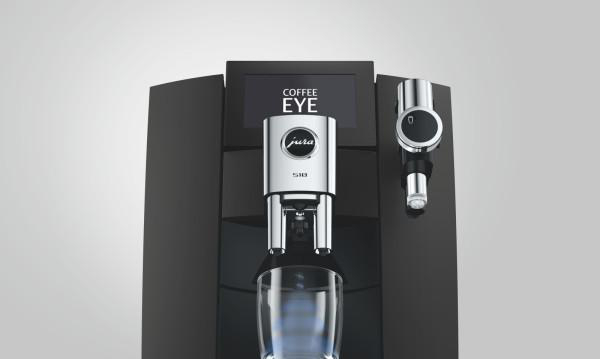 Schwarze Jura Kaffeemaschine mit Display und glänzendem Chromauslauf vor grauem Hintergrund.