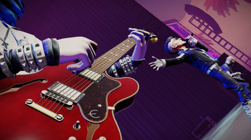 Eine Person spielt eine rote E-Gitarre auf einer Bühne mit anderem Bandmitglied im Hintergrund unter lilafarbenem Licht.