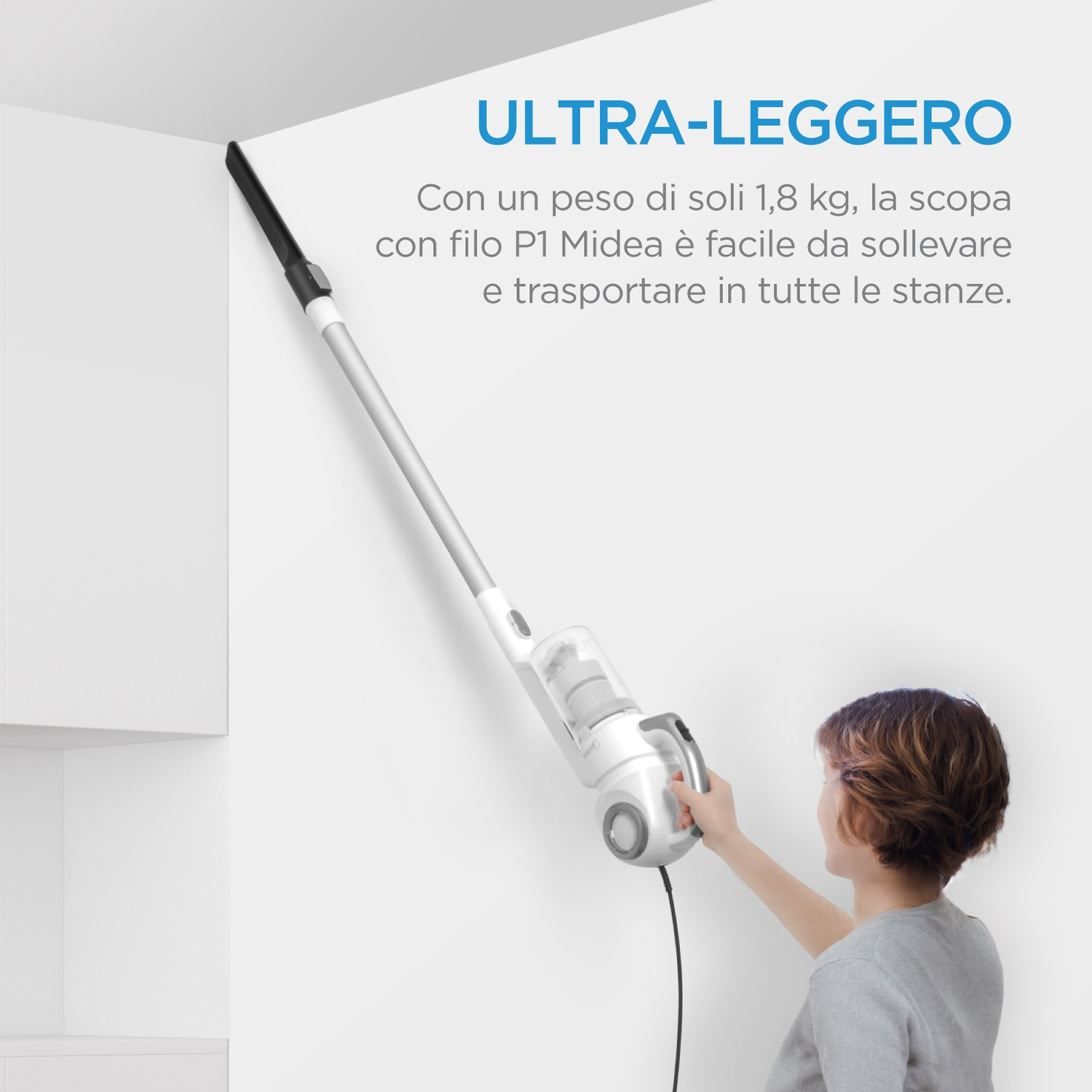 Una persona tiene un aspirapolvere bianco leggero, pulendo l'angolo di una parete alta.