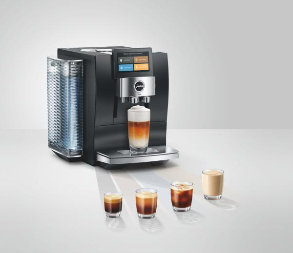 Moderne schwarze Kaffeemaschine mit Display und vier Gläsern mit verschiedenen Kaffeespezialitäten.