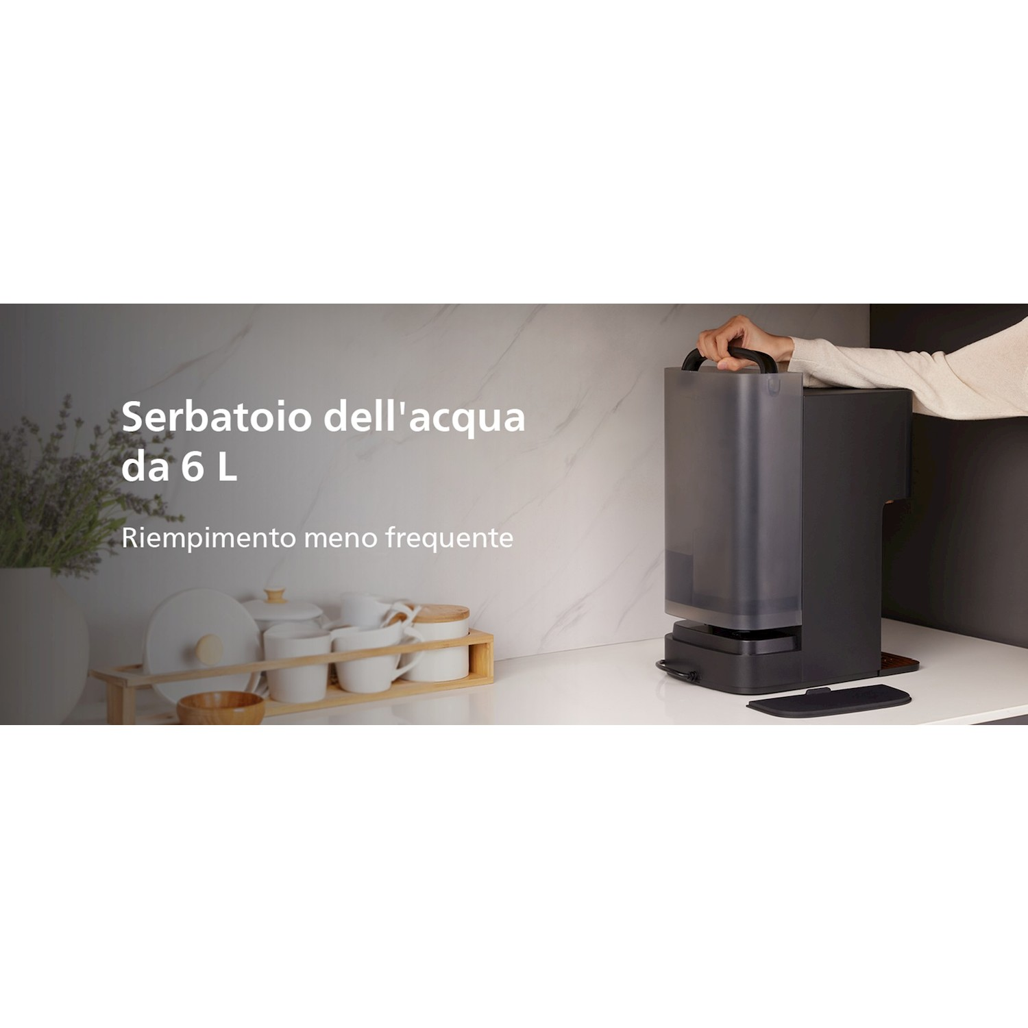 Una persona regge il serbatoio d'acqua da 6L di una macchina da caffè nera su un piano.