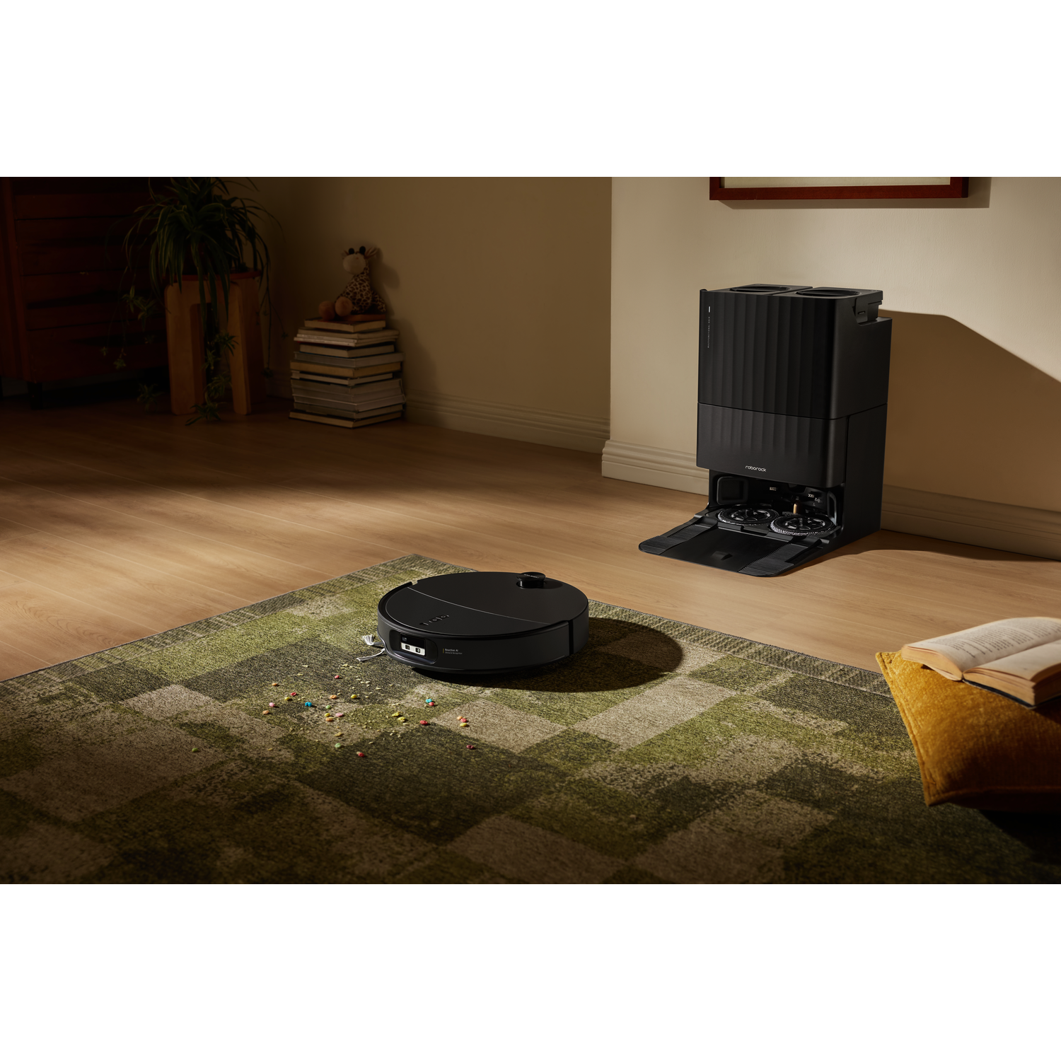 Un aspirateur robot noir nettoie un tapis vert dans un salon chaleureux près de sa station.
