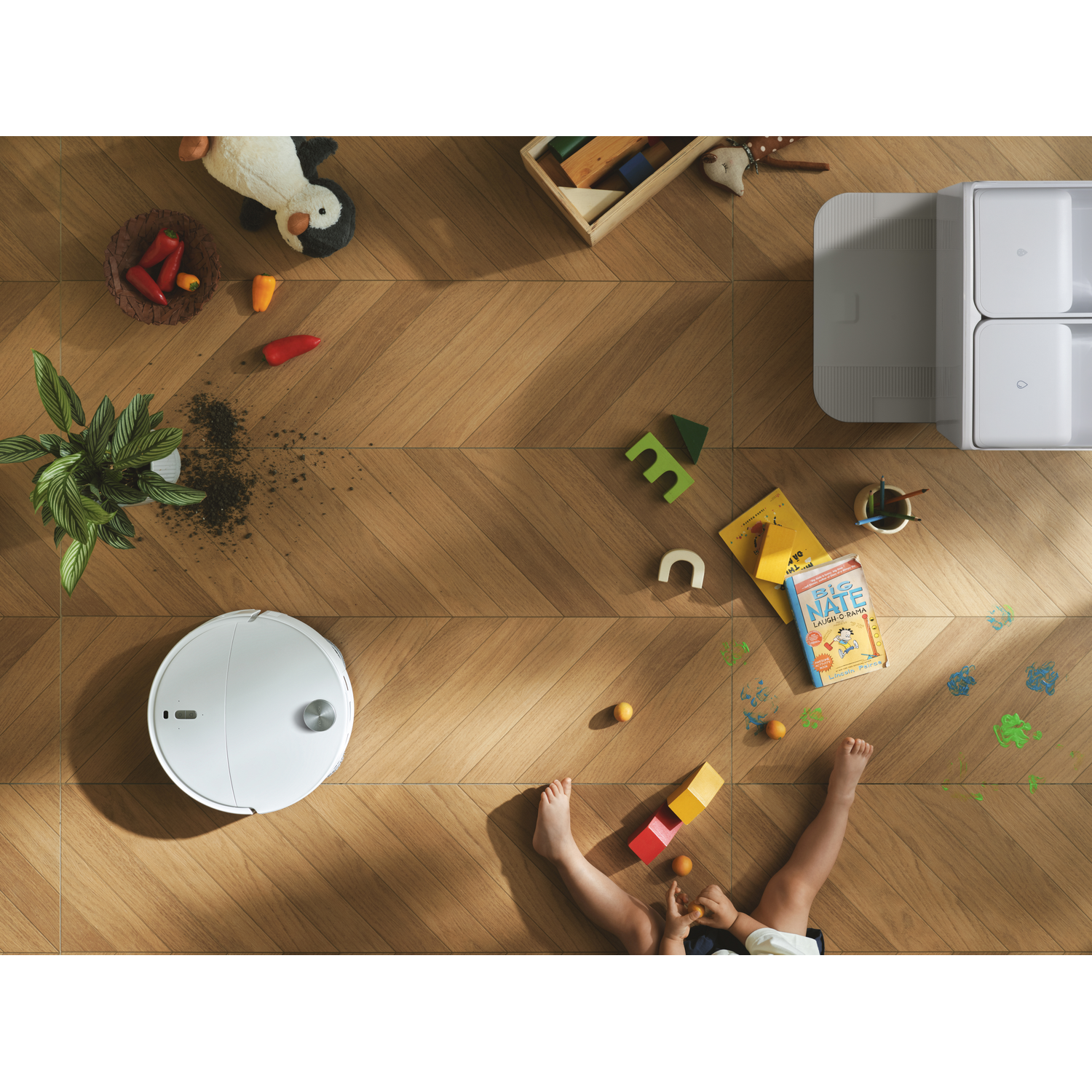 Aspirateur robot sur sol en bois dans une chambre d'enfant avec jouets et terre.