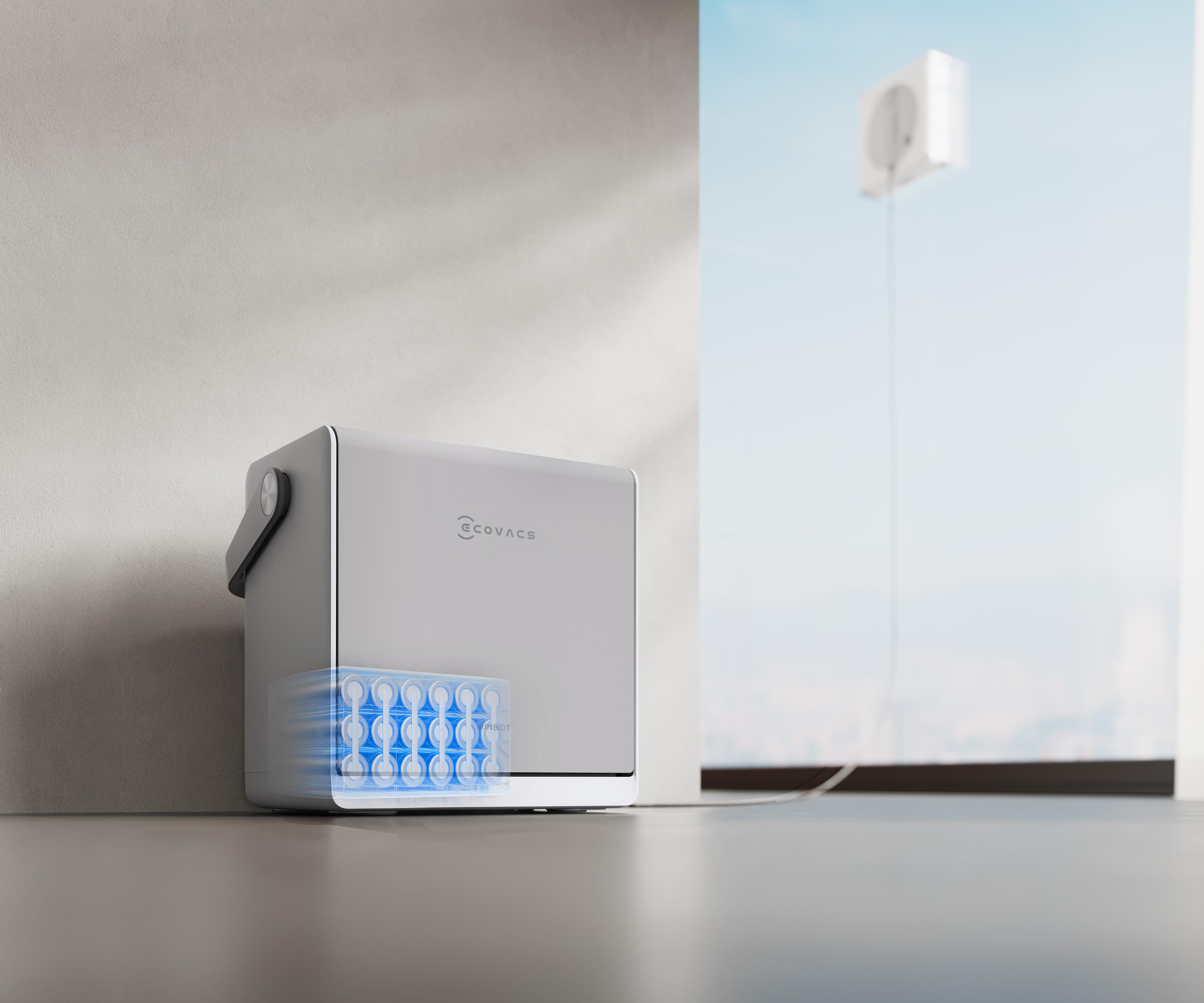 Eine weiße Ecovacs-Box mit sichtbaren Batterien steht drinnen, während ein Roboter ein Fenster im Hintergrund putzt.