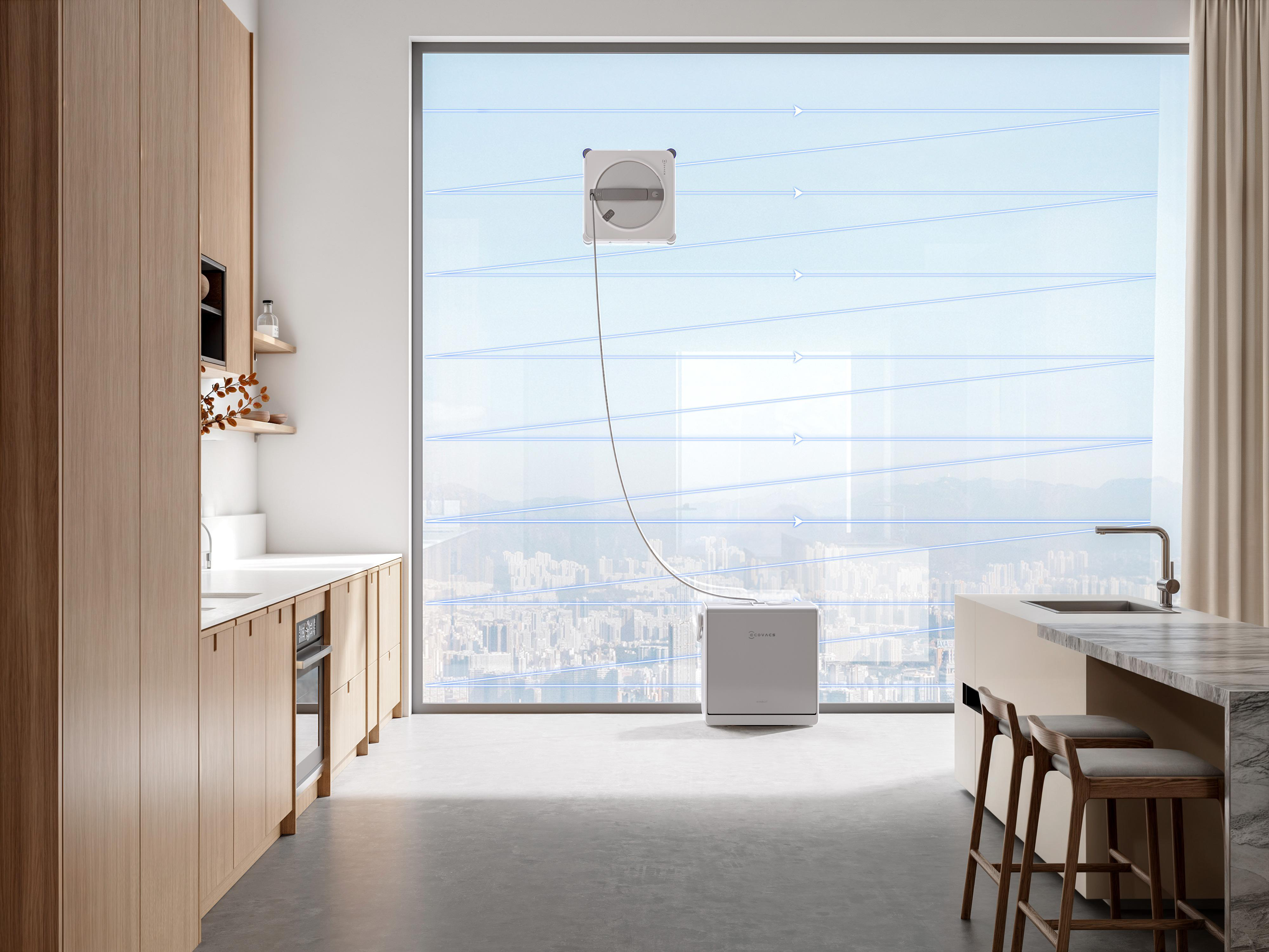 Ein Fensterputzroboter reinigt ein großes Wohnungsfenster mit Blick auf eine Stadt, verbunden mit einer Basisstation.