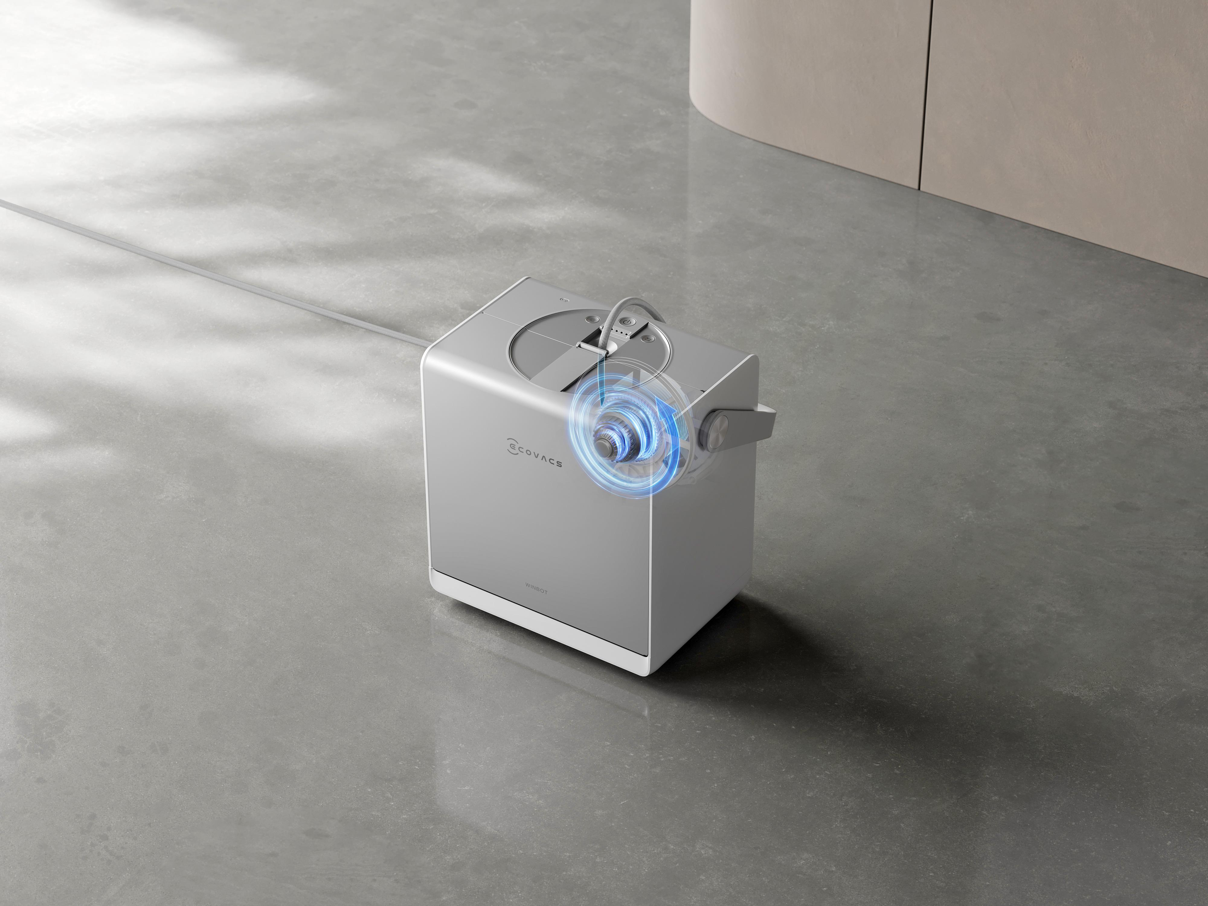 Ein silbernes Ecovacs-Gerät mit blauen grafischen Welleneffekten steht auf einem glänzenden Betonboden.