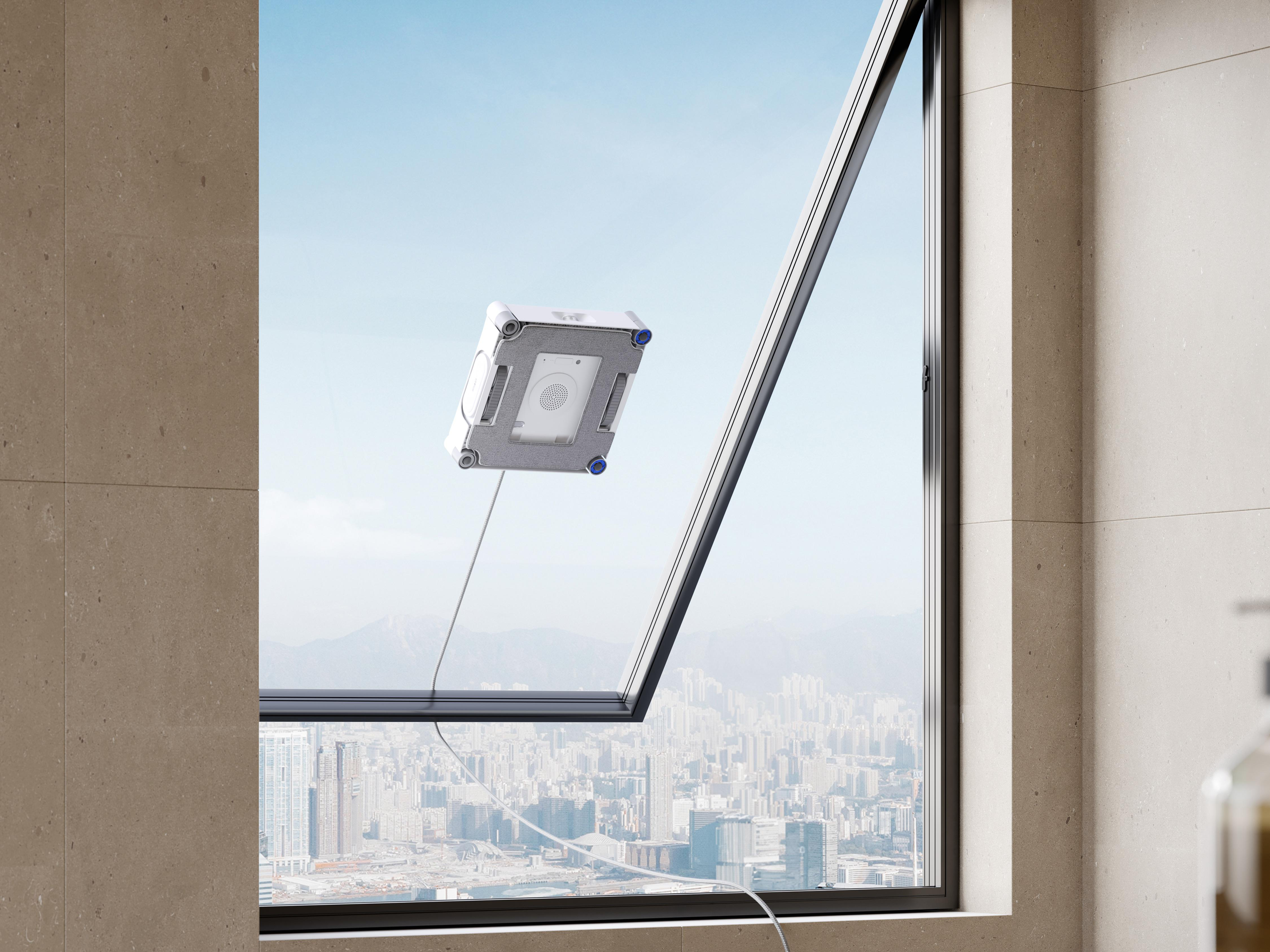 Ein weißer Fenstersauger reinigt eine Fensterscheibe mit Blick auf eine ferne Stadt.
