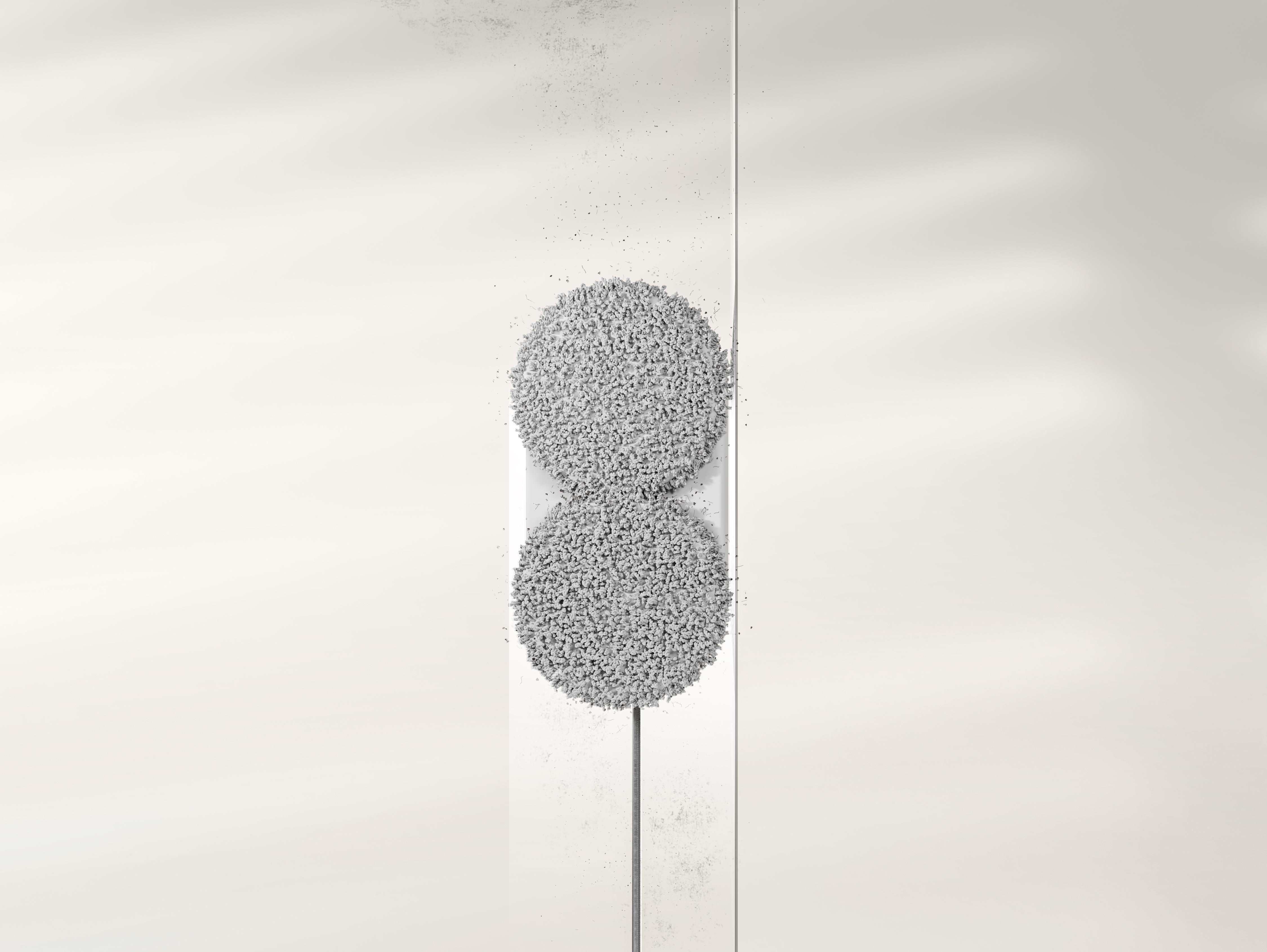 Ein weißer Roboterreiniger wäscht eine glatte, helle Wand mit zwei runden Mopps.