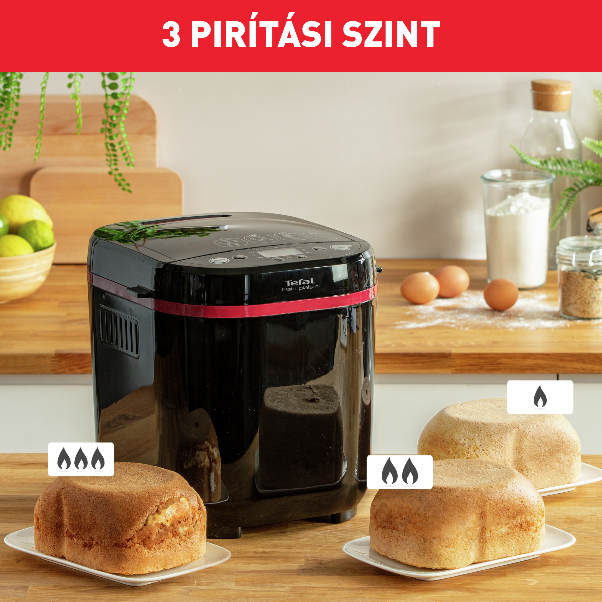 Egy fekete Tefal kenyérsütő gép előtte három különböző pirítási szintű sült kenyérrel tányérokon.