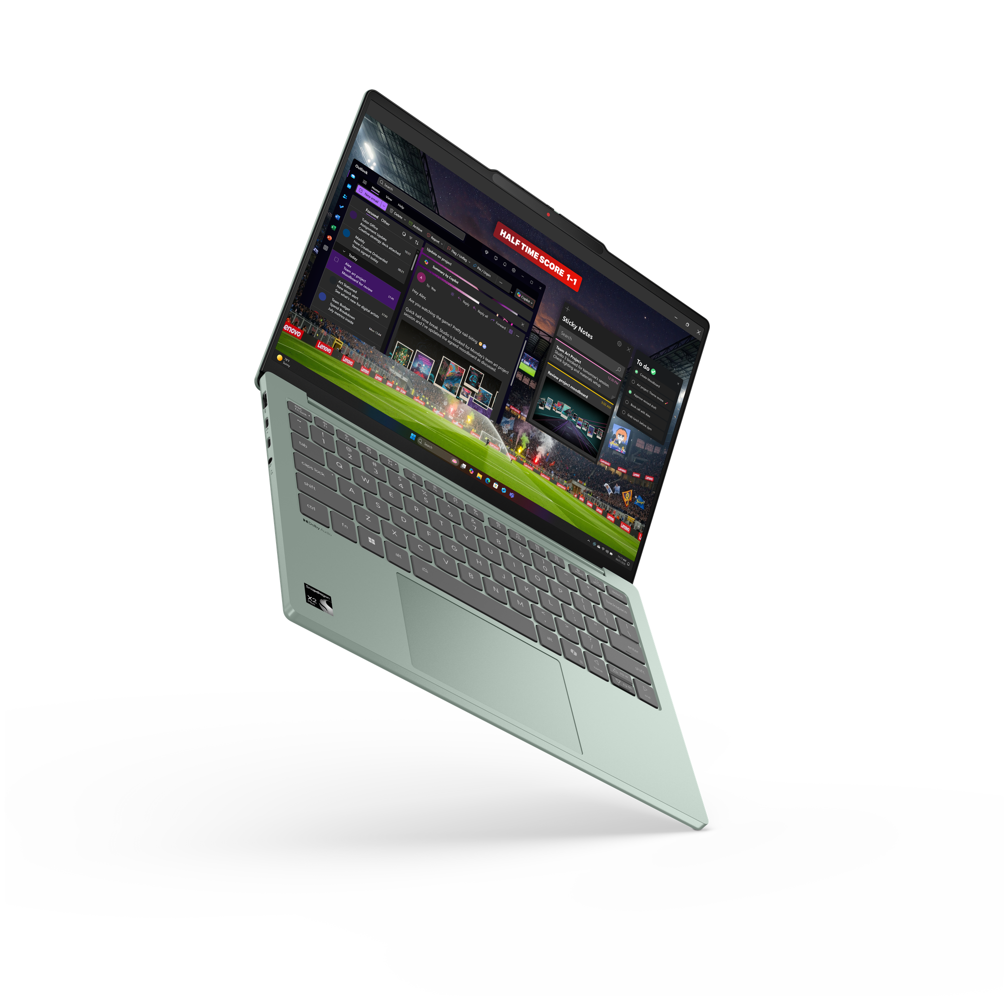 Ein offener, mintgrüner Laptop mit beleuchtetem Bildschirm zeigt geöffnete Apps und ein Fußballspiel vor schwarzem Hintergrund.