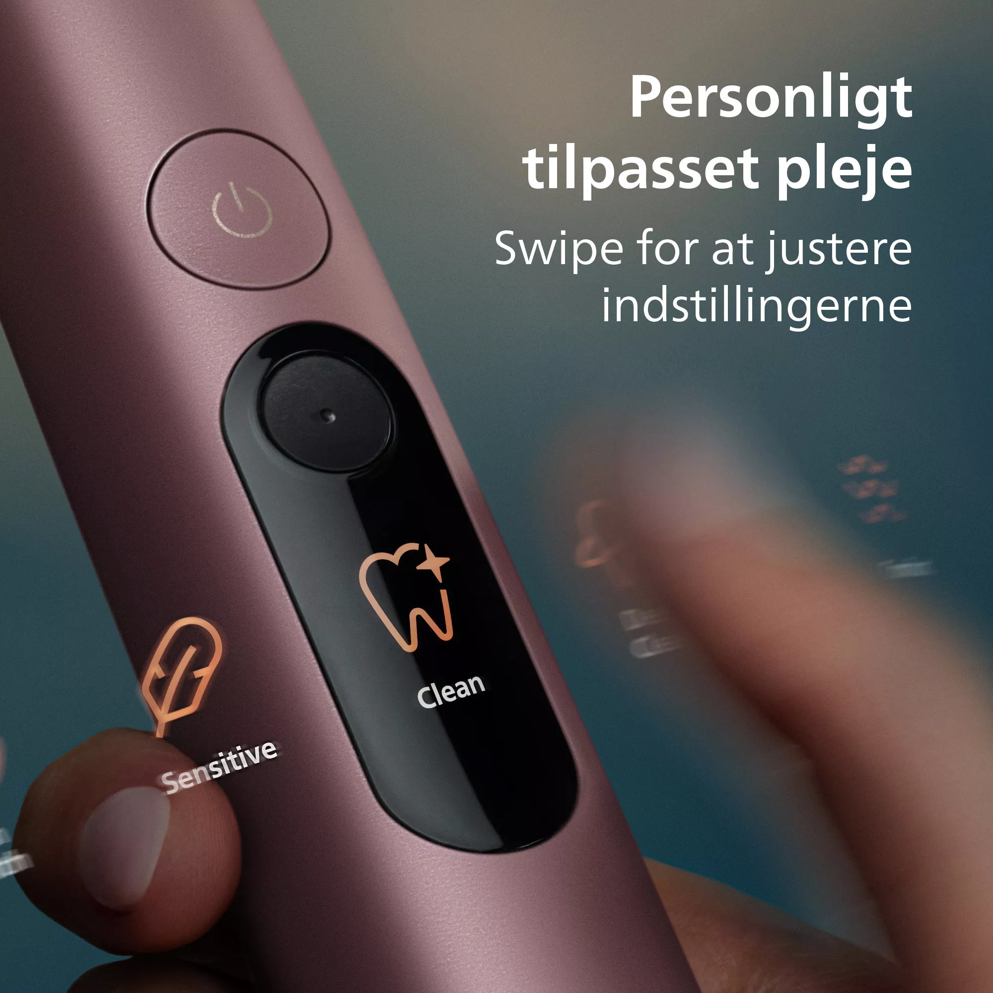 Egy kéz egy rózsaszín fogkefe érintőkijelzőjét használja. Dán szöveg a háttérben.