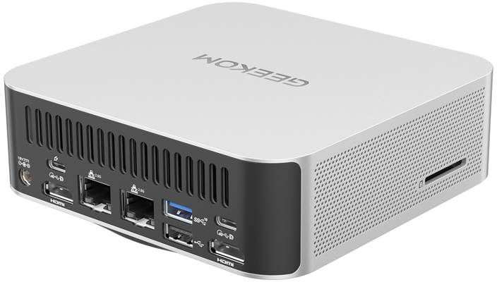 Ezüstszínű Geekom mini PC hátulján különböző csatlakozókkal, felül márkajelzéssel.