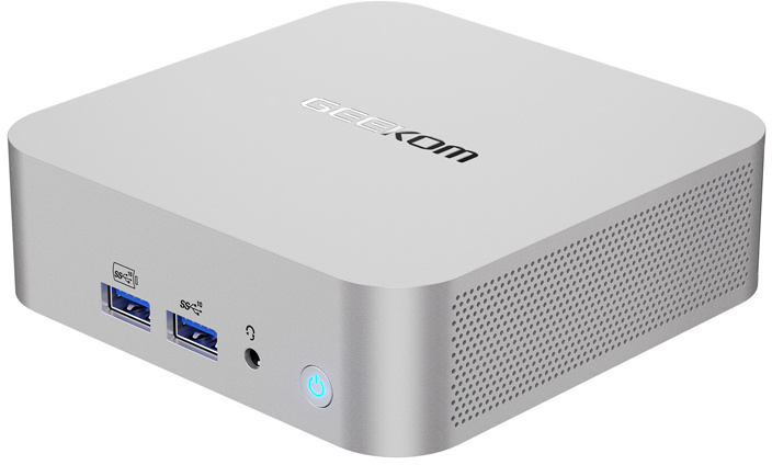Egy ezüst színű mini PC előlapi USB-portokkal, audiócsatlakozóval és bekapcsológombbal, felül Geekom logóval.