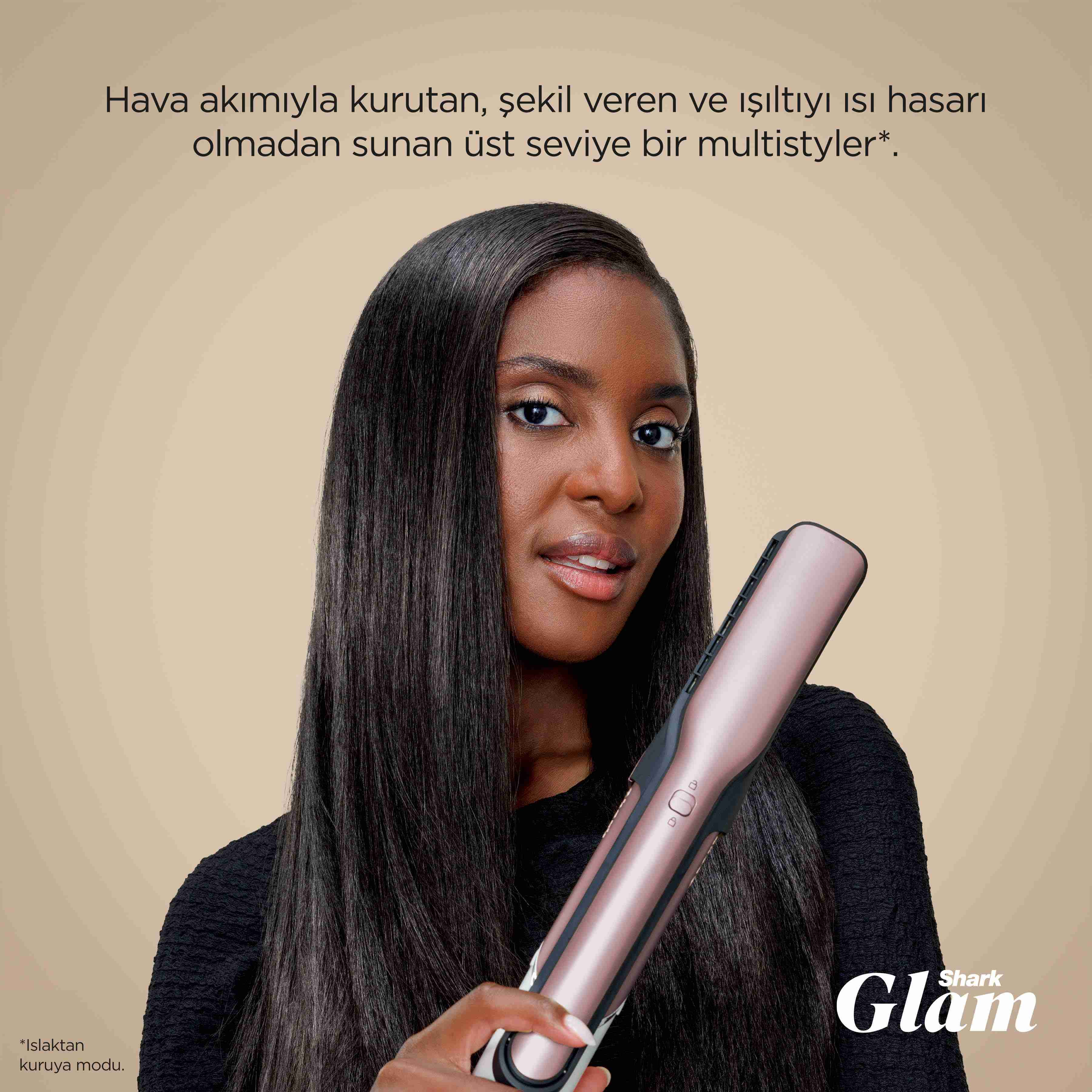 Düz saçlı bir kadın, bej arka plan önünde pembe altın rengi Shark Glam saç şekillendirici tutuyor.