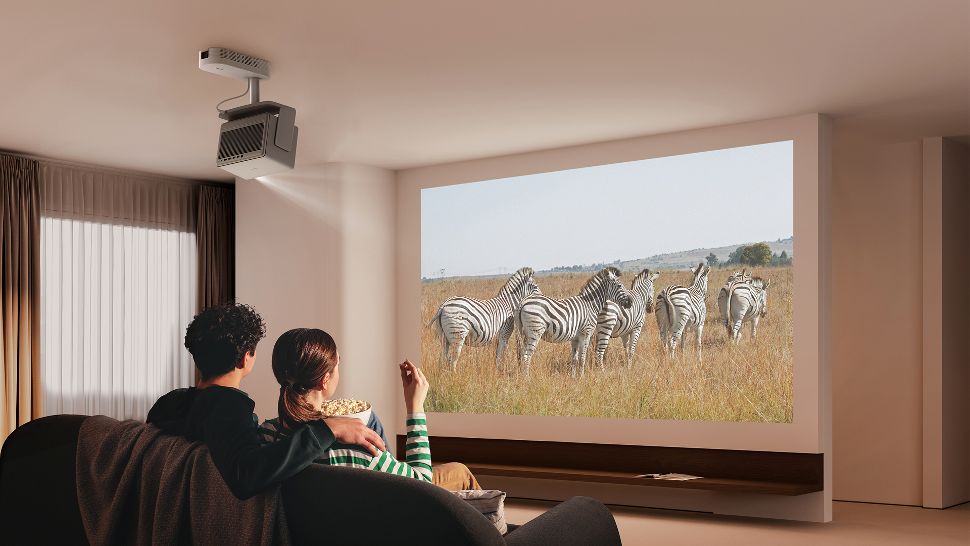 Bir çift kanepede oturmuş, patlamış mısır yiyerek büyük ekranda zebra izliyor.