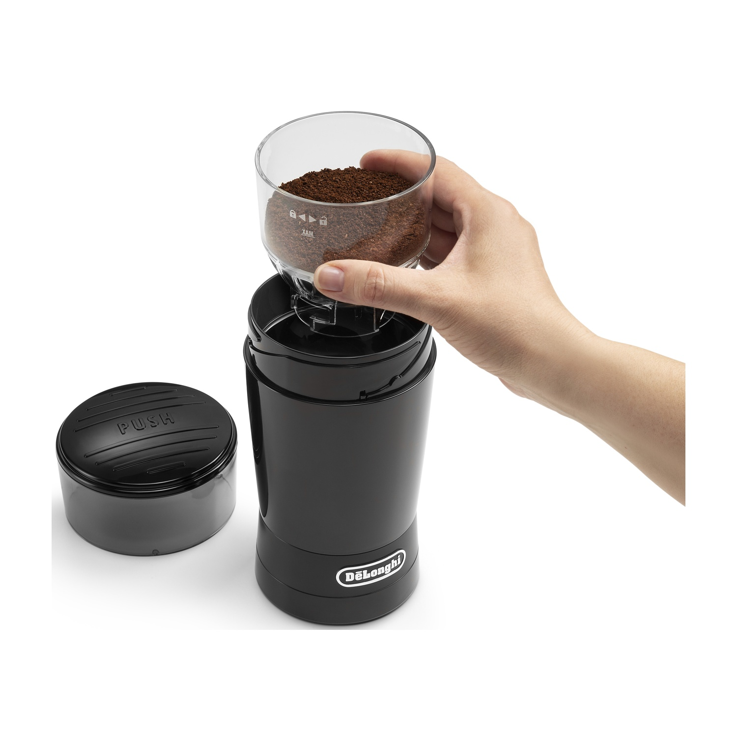 Una mano tiene il contenitore del caffè macinato di un macinacaffè nero.