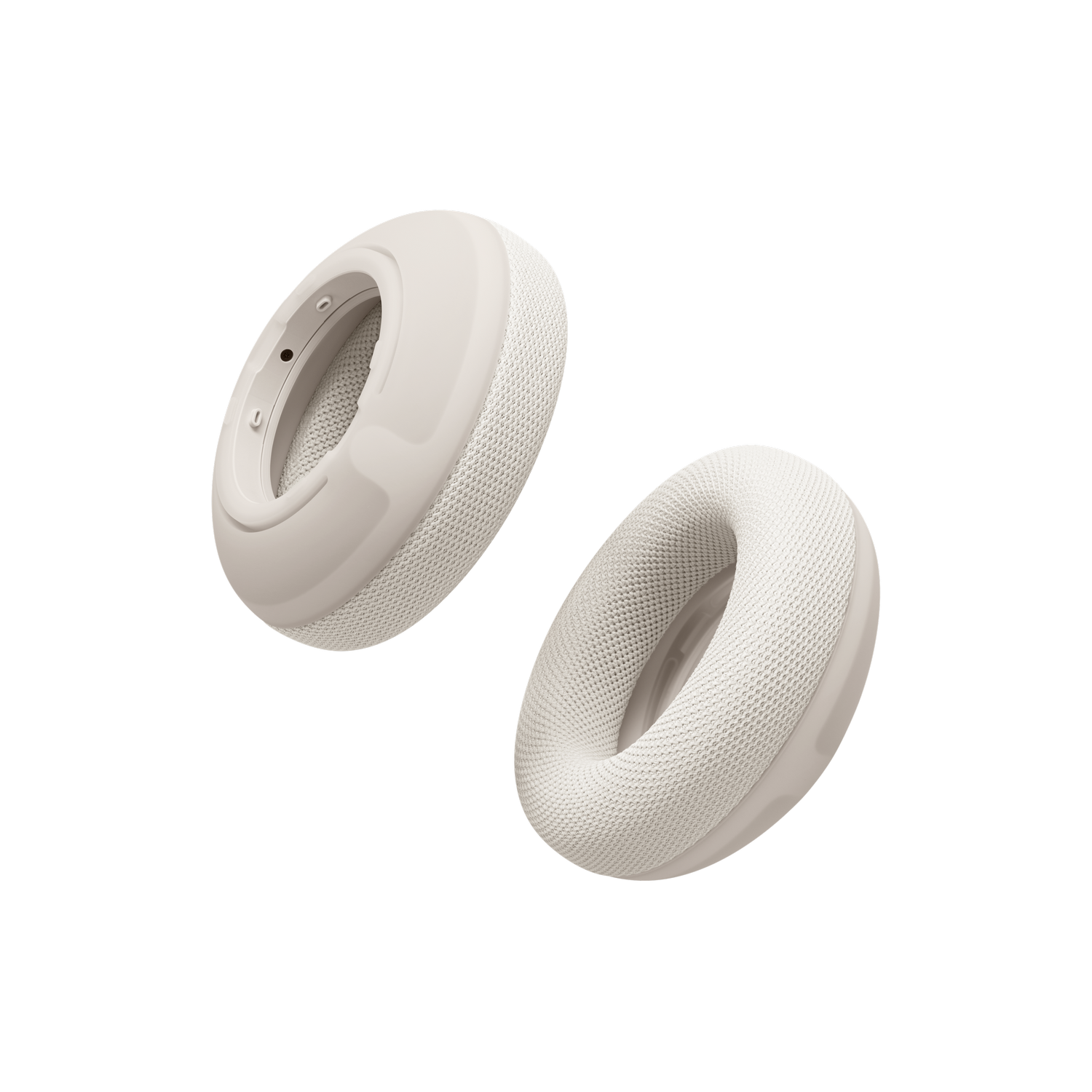 Dos almohadillas de auriculares de color crema flotan sobre fondo negro.