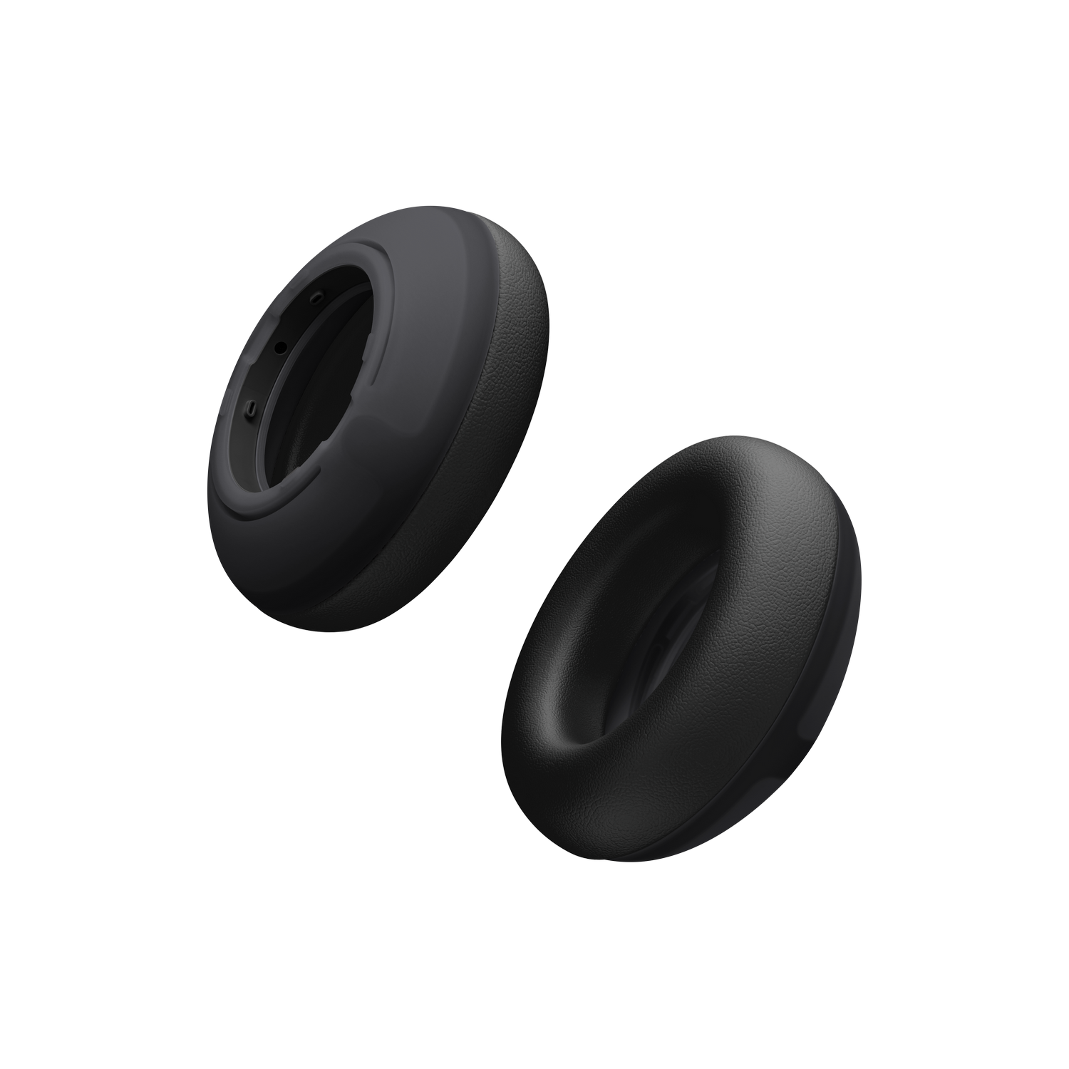 Dos almohadillas negras para auriculares flotan sobre un fondo negro.