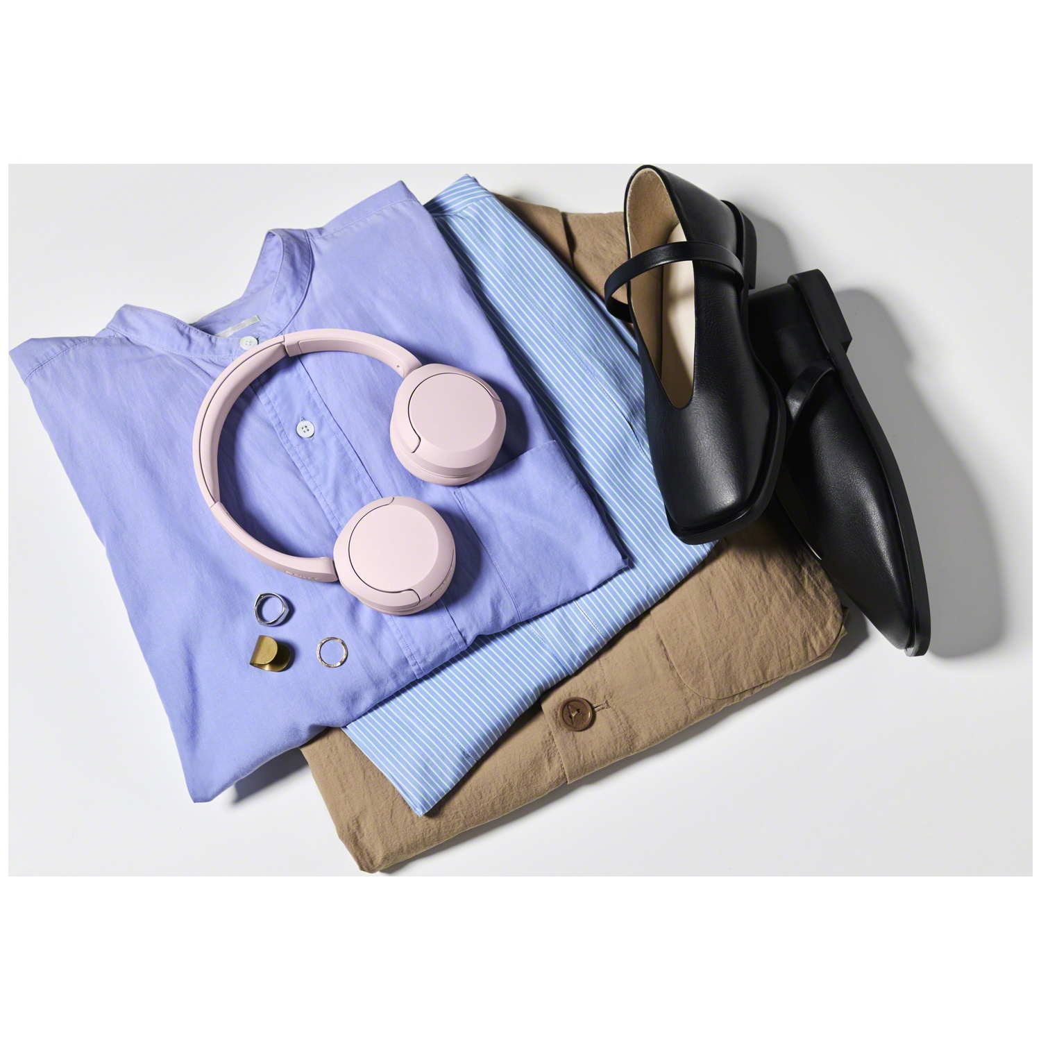 Ensemble de vêtements avec chemise bleue, chemise rayée, veste beige, chaussures noires, casque rose et bagues.