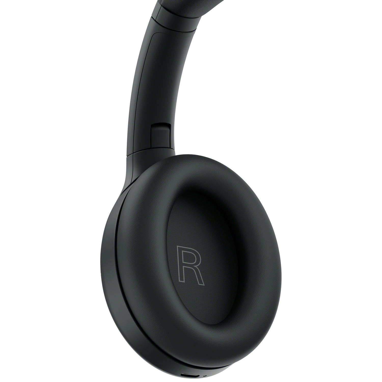 Gros plan d'un casque circum-auriculaire noir avec la lettre R sur l'écouteur droit sur fond blanc.