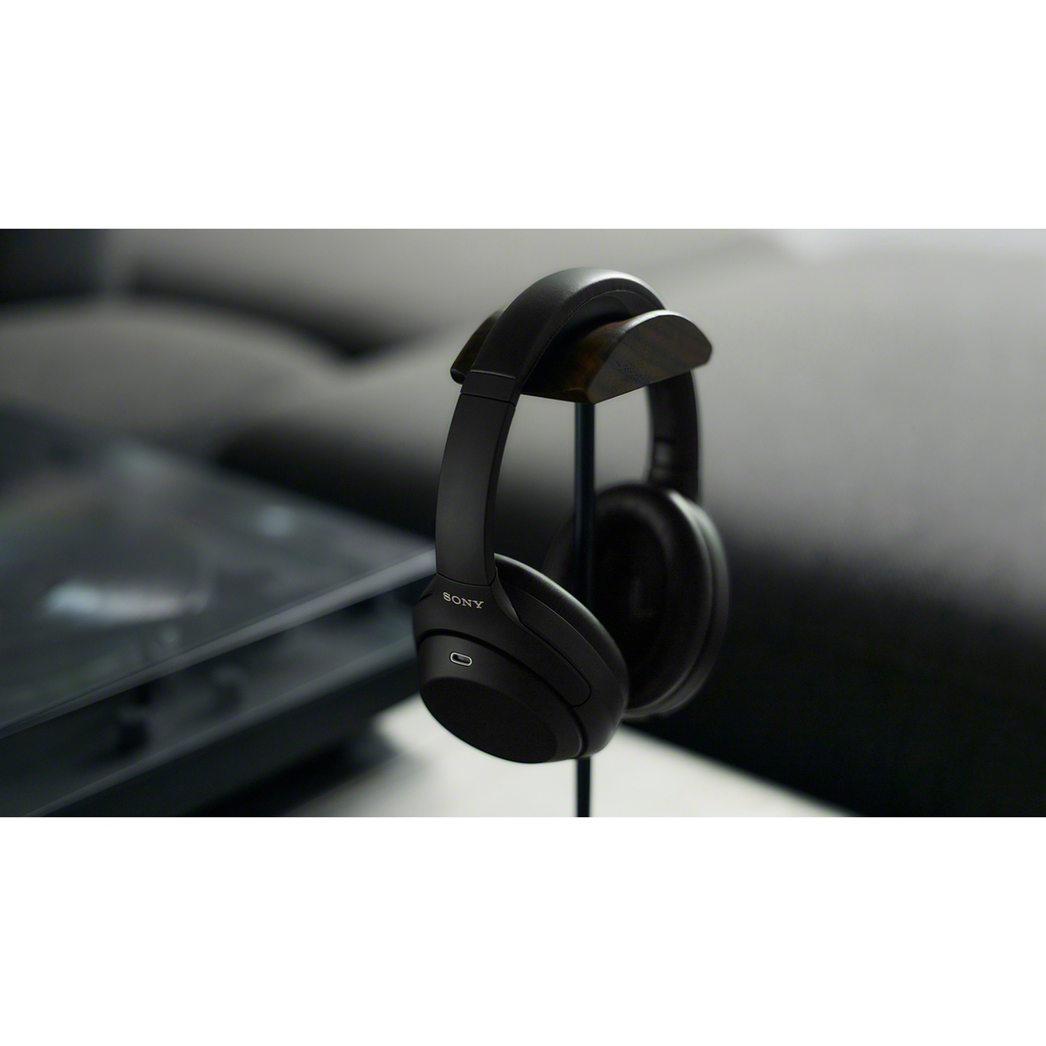 Casque noir Sony accroché sur un support sur fond flou.