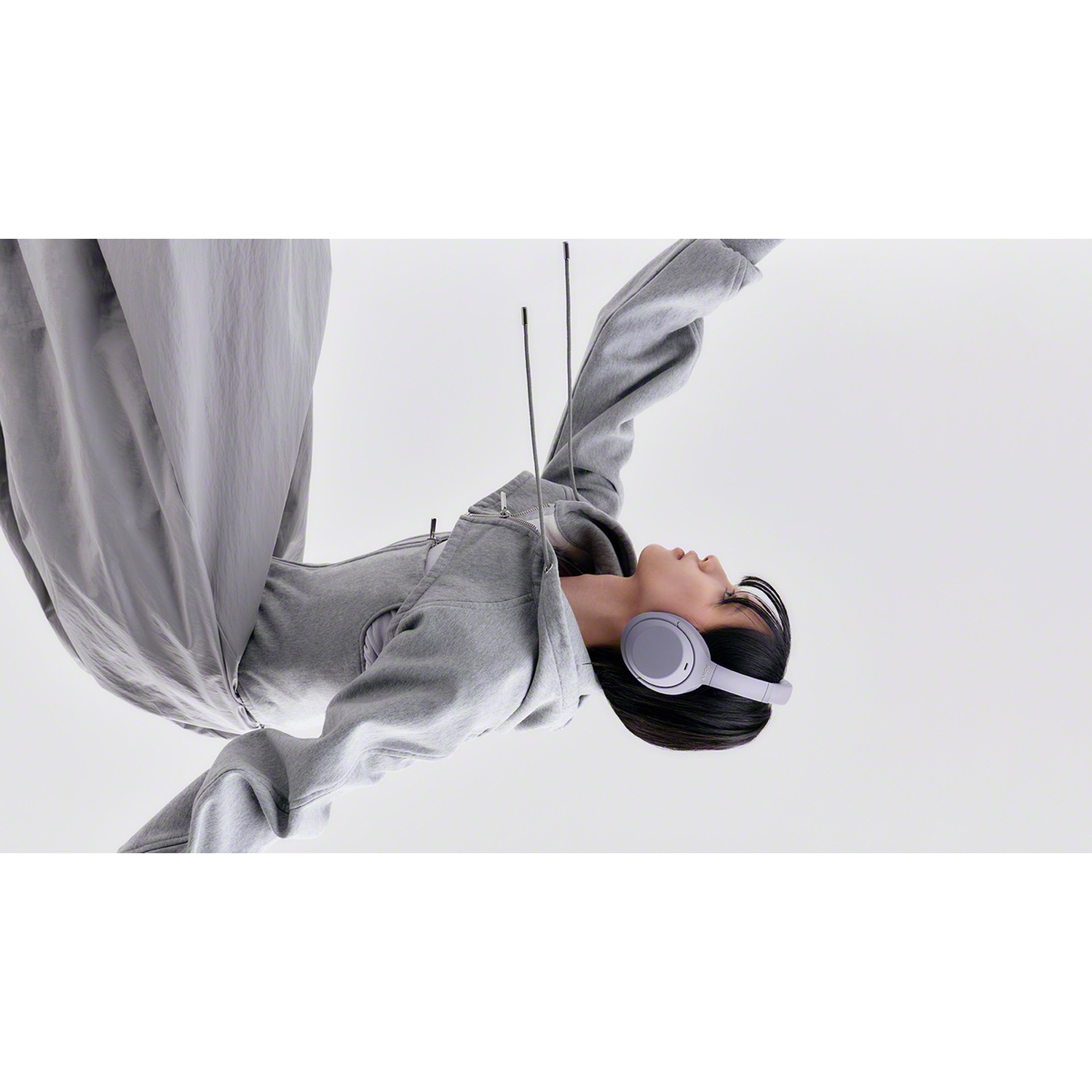 Une personne en vêtements gris portant un casque gris sur fond clair.