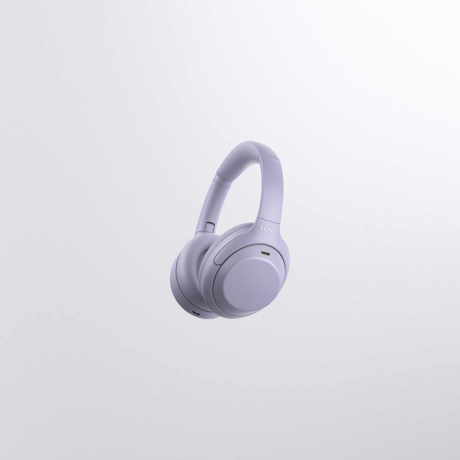 Casque sans fil Sony lilas flottant sur un fond gris clair uni.