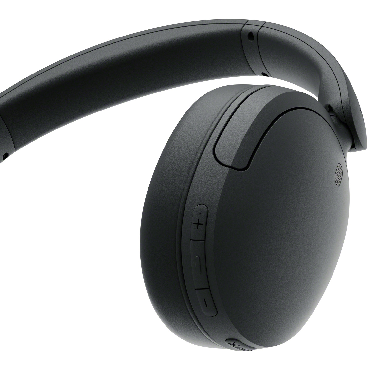 Gros plan d'un casque sans fil noir montrant les boutons de volume sur l'écouteur sur fond blanc.