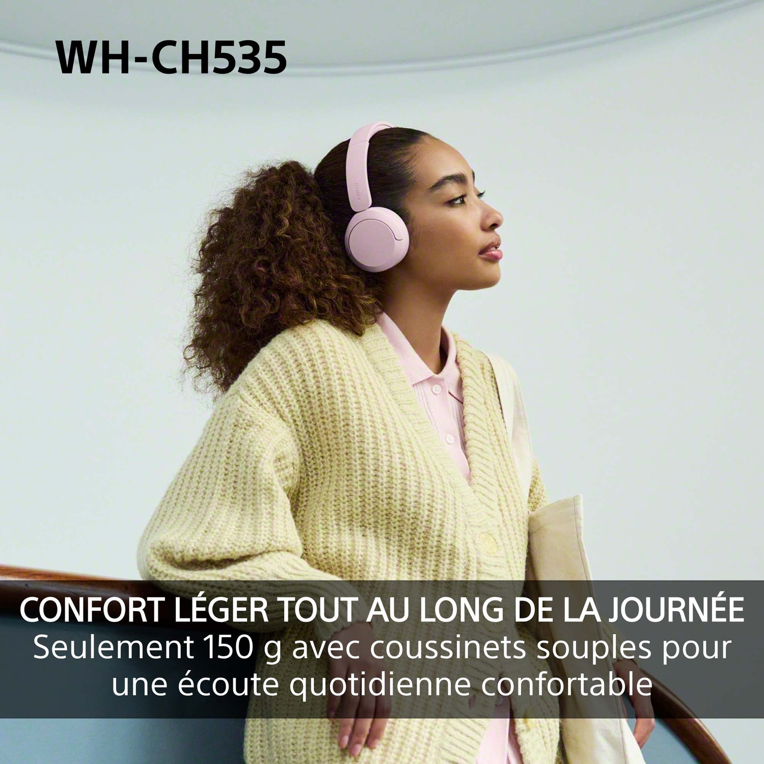 Femme portant un casque rose et un gilet beige regarde sur le côté.
