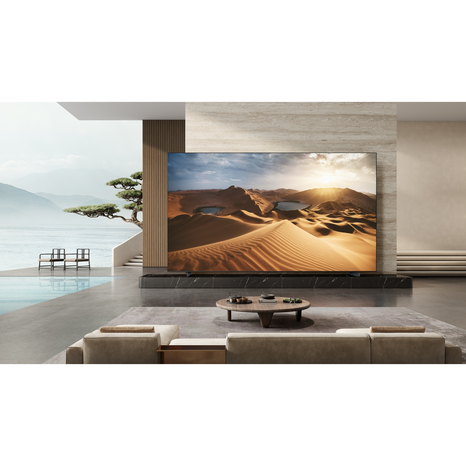 Una grande TV mostra un deserto in un soggiorno moderno con vista sull'acqua.