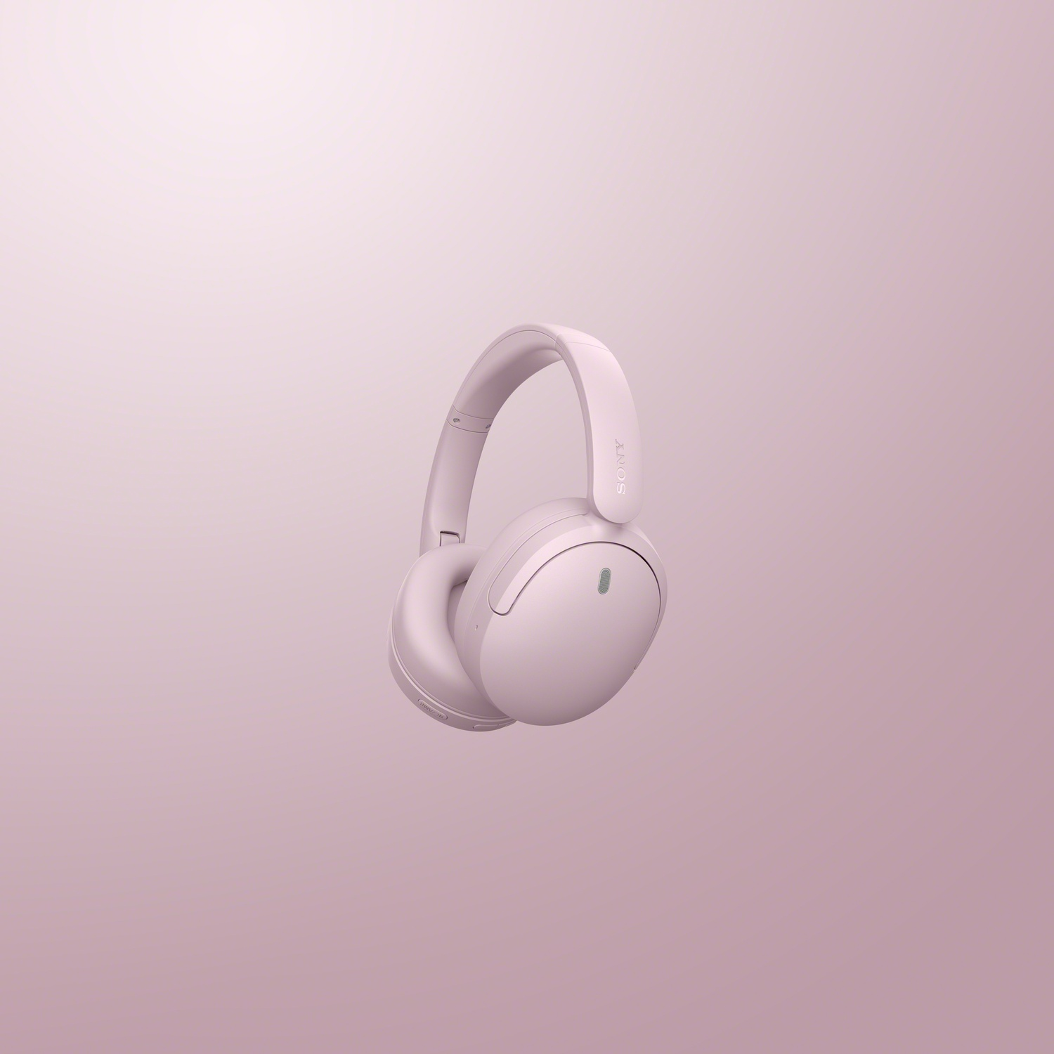 Un casque sans fil Sony rose flotte sur un fond rose uni.