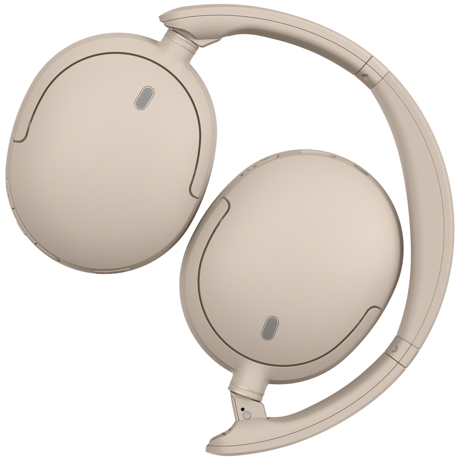 Casque sans fil beige sur fond blanc, vu du dessus.