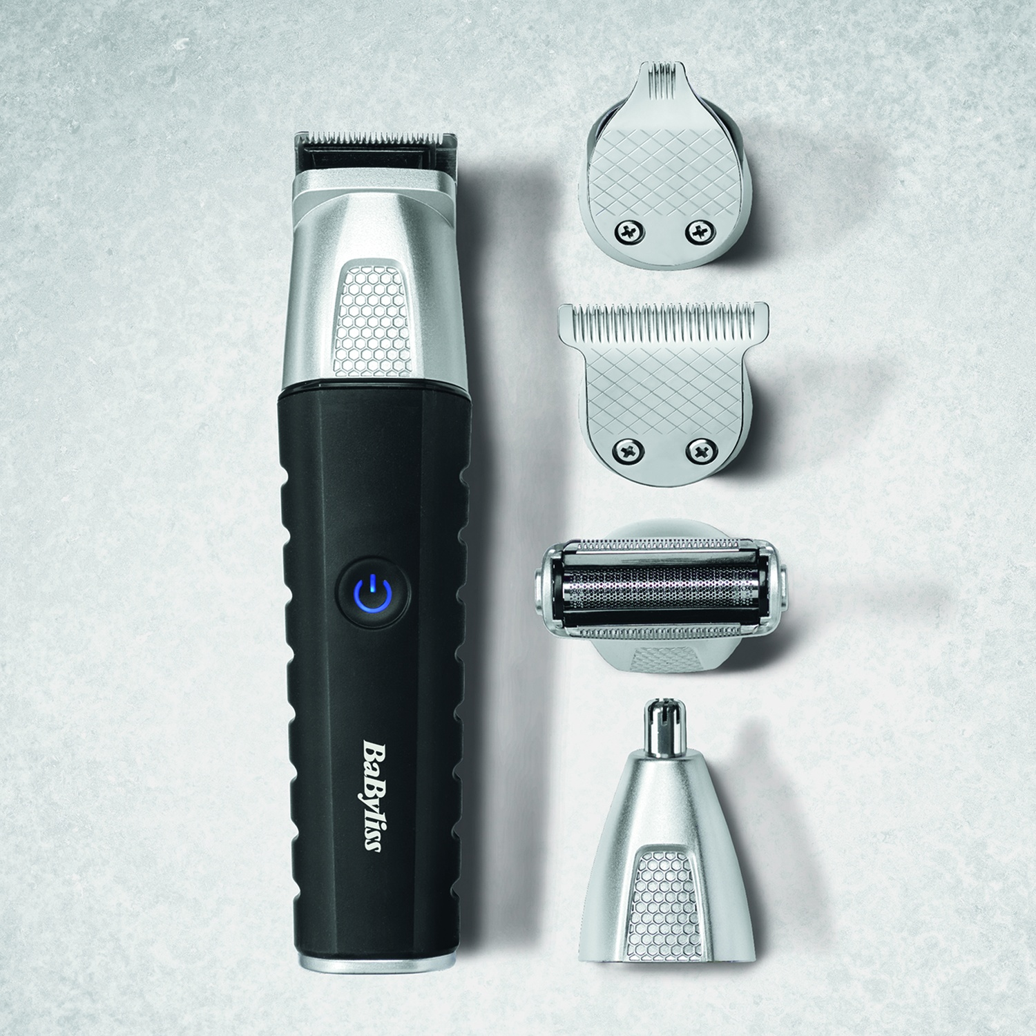 Rasoio BaByliss nero e argento con quattro diversi accessori su sfondo grigio.