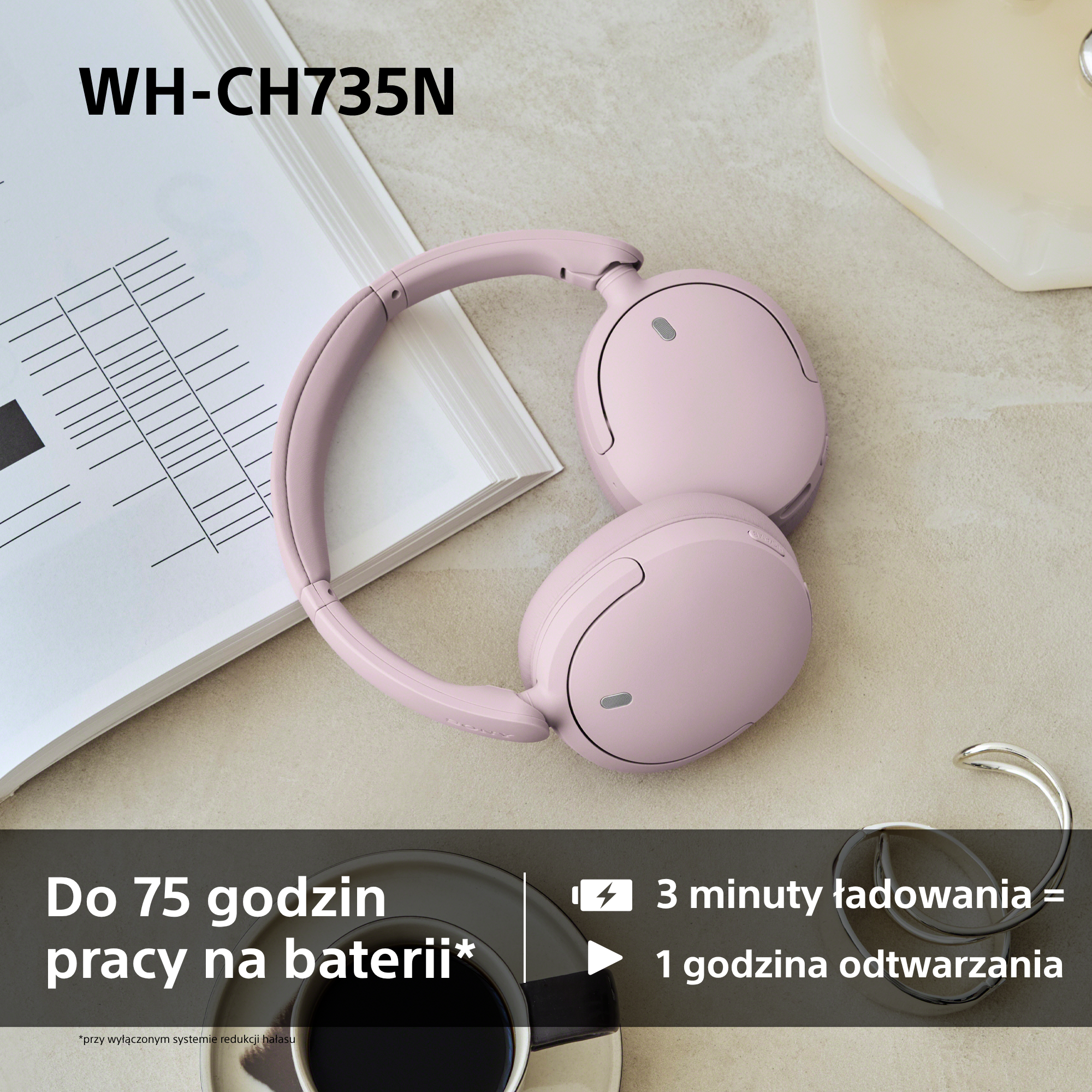 Różowe słuchawki na stole obok otwartej książki, filiżanki kawy i biżuterii.