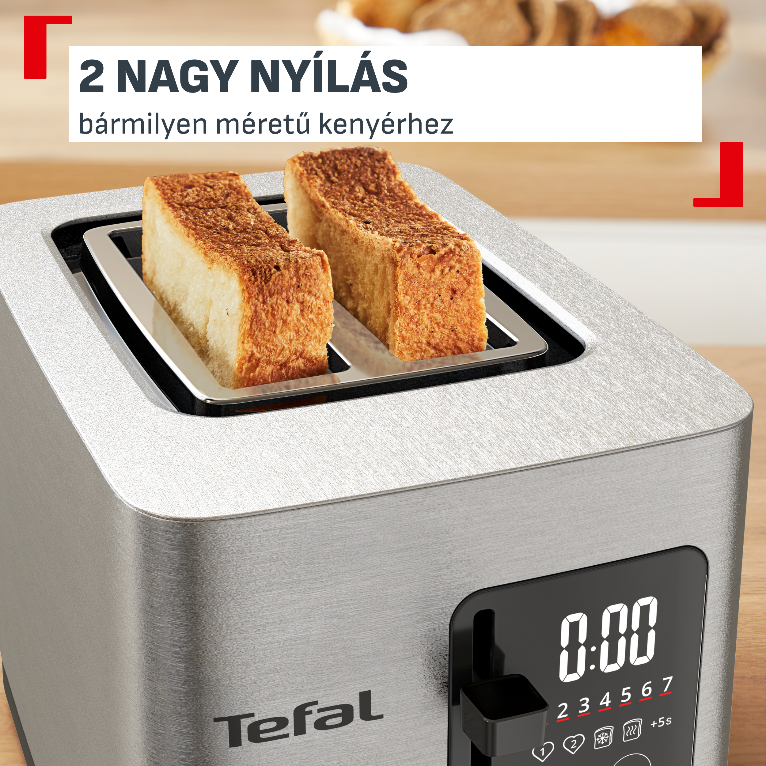 Egy ezüstszínű Tefal kenyérpirító két szelet pirítóssal és digitális vezérlőpanellel.