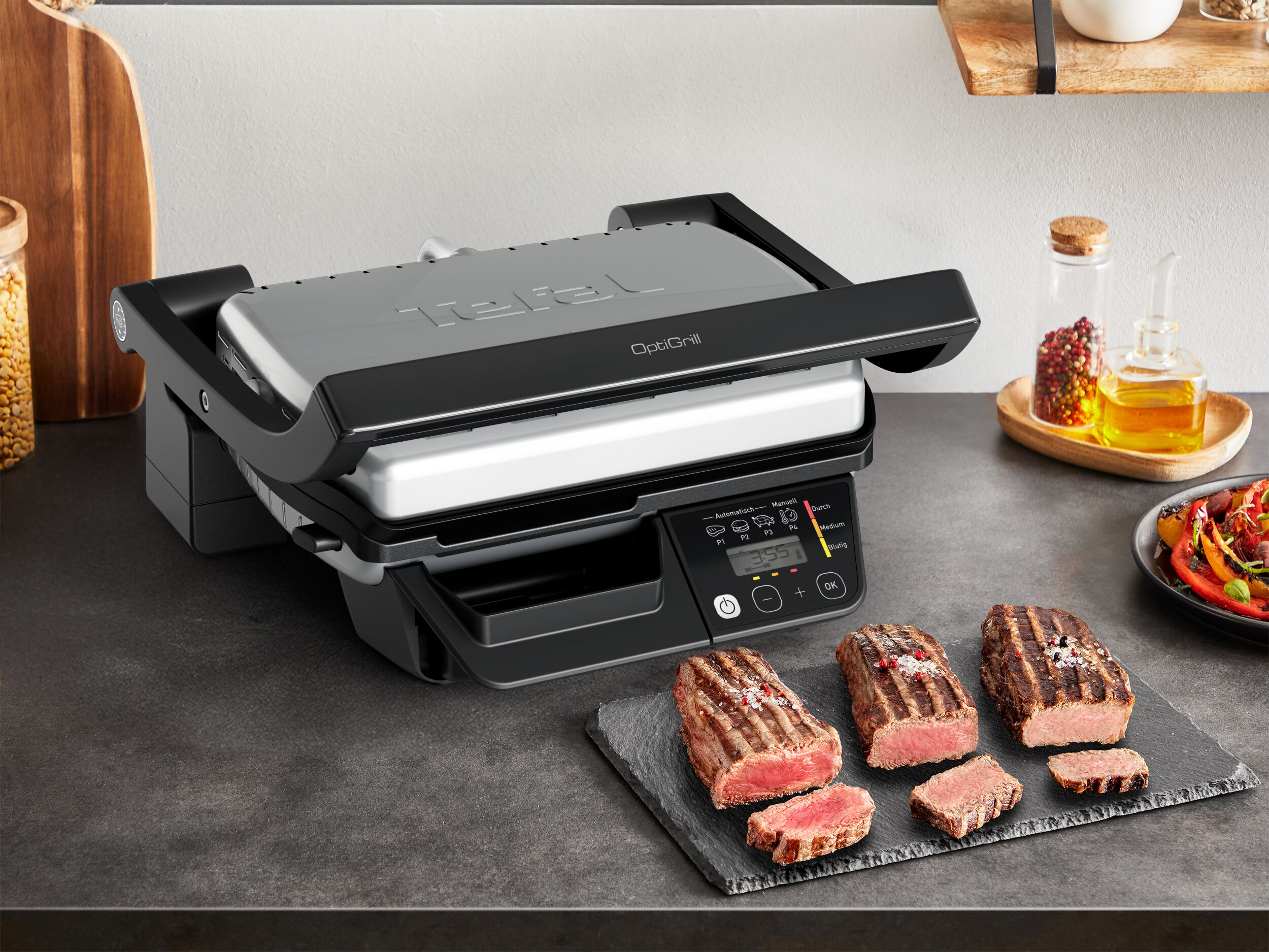 Egy Tefal OptiGrill a konyhapulton, mellette frissen grillezett és felszeletelt steak egy palatáblán.