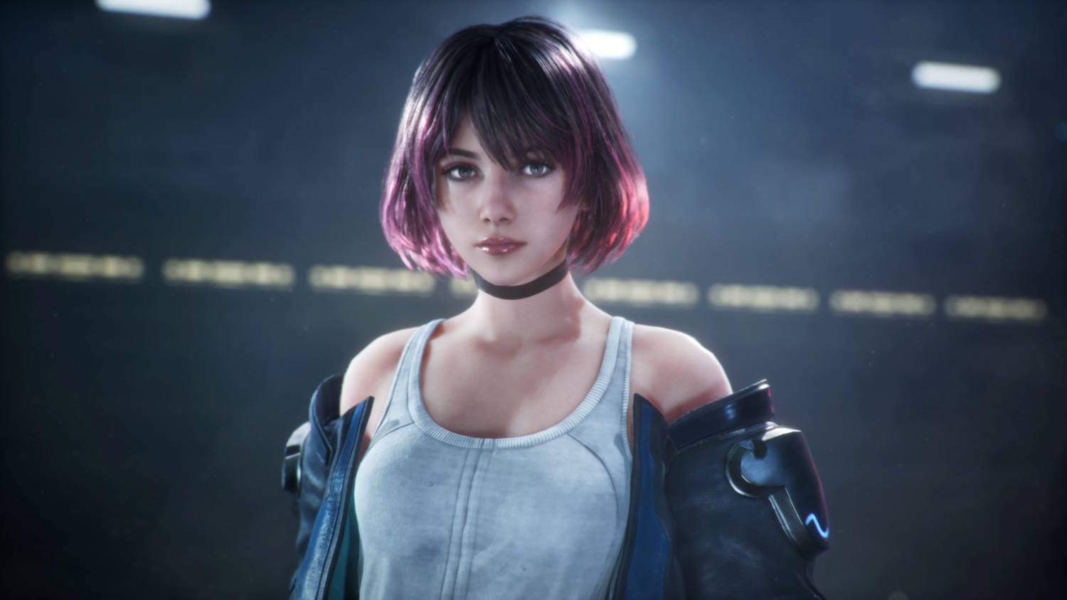 Una mujer con cabello corto morado, camiseta blanca y chaqueta negra está frente a un fondo oscuro.