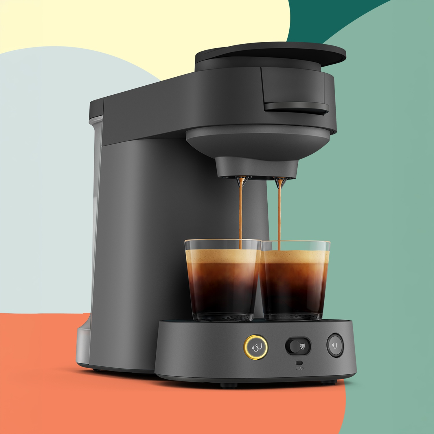 Une cafetière grise verse du café fraîchement préparé dans deux verres sur fond abstrait coloré.