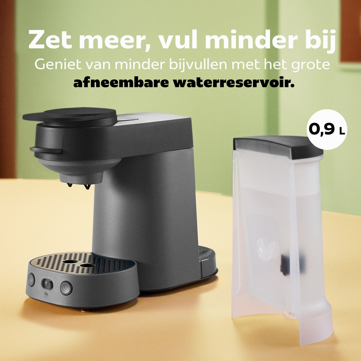 Een grijs koffiezetapparaat met een 0,9 liter watertank op een tafel.