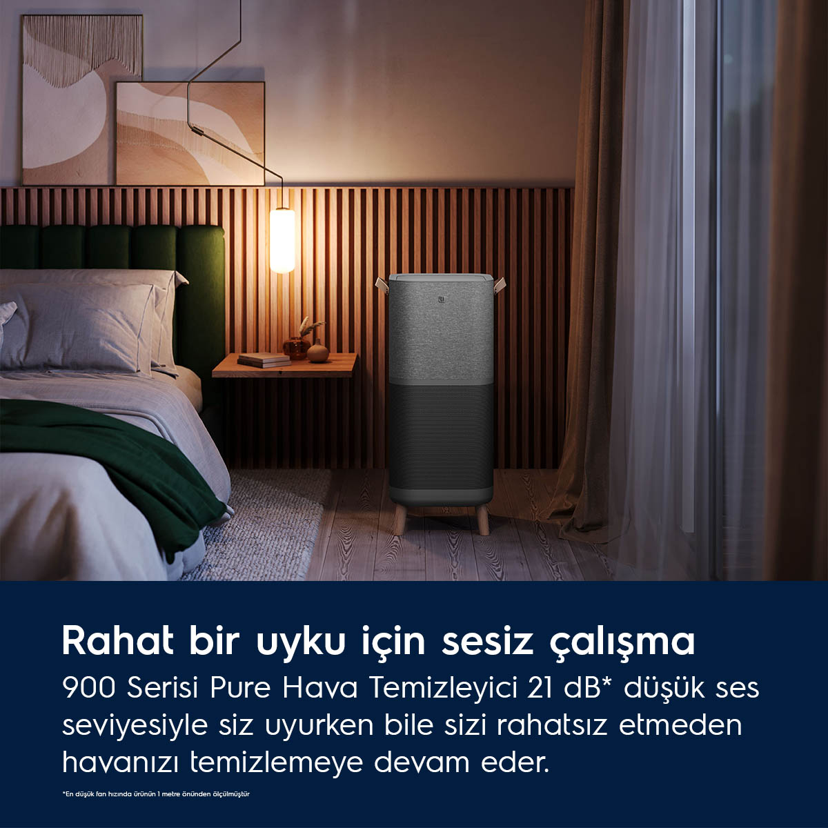 Gri bir hava temizleyici, yatak odasında yatağın yanında duruyor.