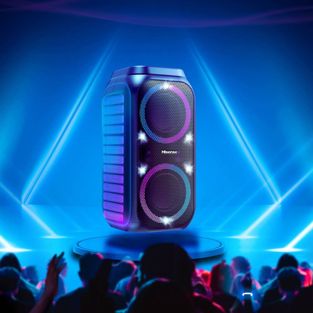 Un altavoz de fiesta Hisense azul con luces en un escenario frente a una multitud bailando.