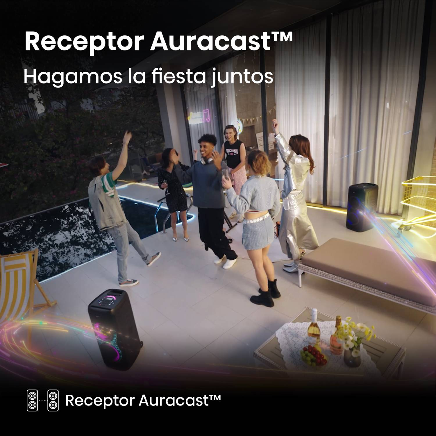Un grupo de amigos diversos baila y socializa en una terraza iluminada con altavoces y una piscina de noche.