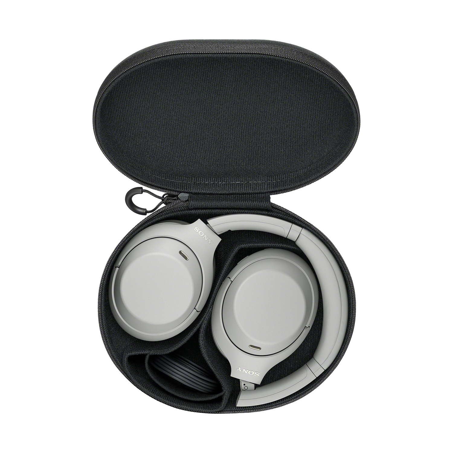 Cuffie grigie Sony ripiegate ordinatamente nella custodia rigida nera aperta su sfondo bianco.