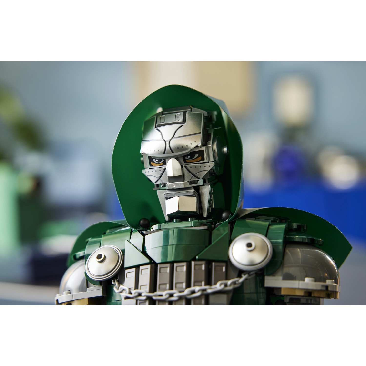 Una dettagliata statuetta Lego del Dottor Destino con mantello verde e armatura metallica su sfondo sfocato.